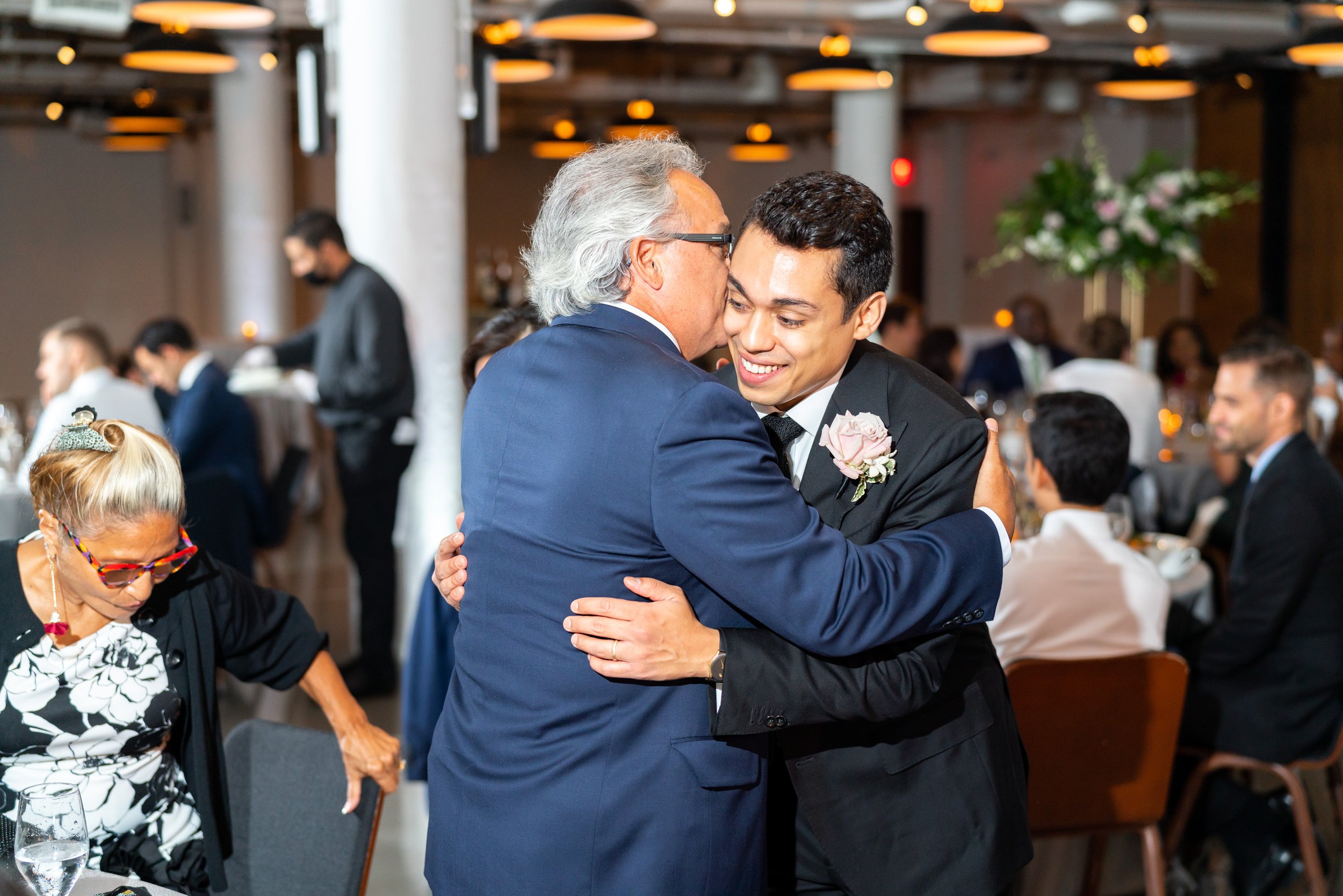 Groom hugs guest at fun wedding reception at the Eaton hotel