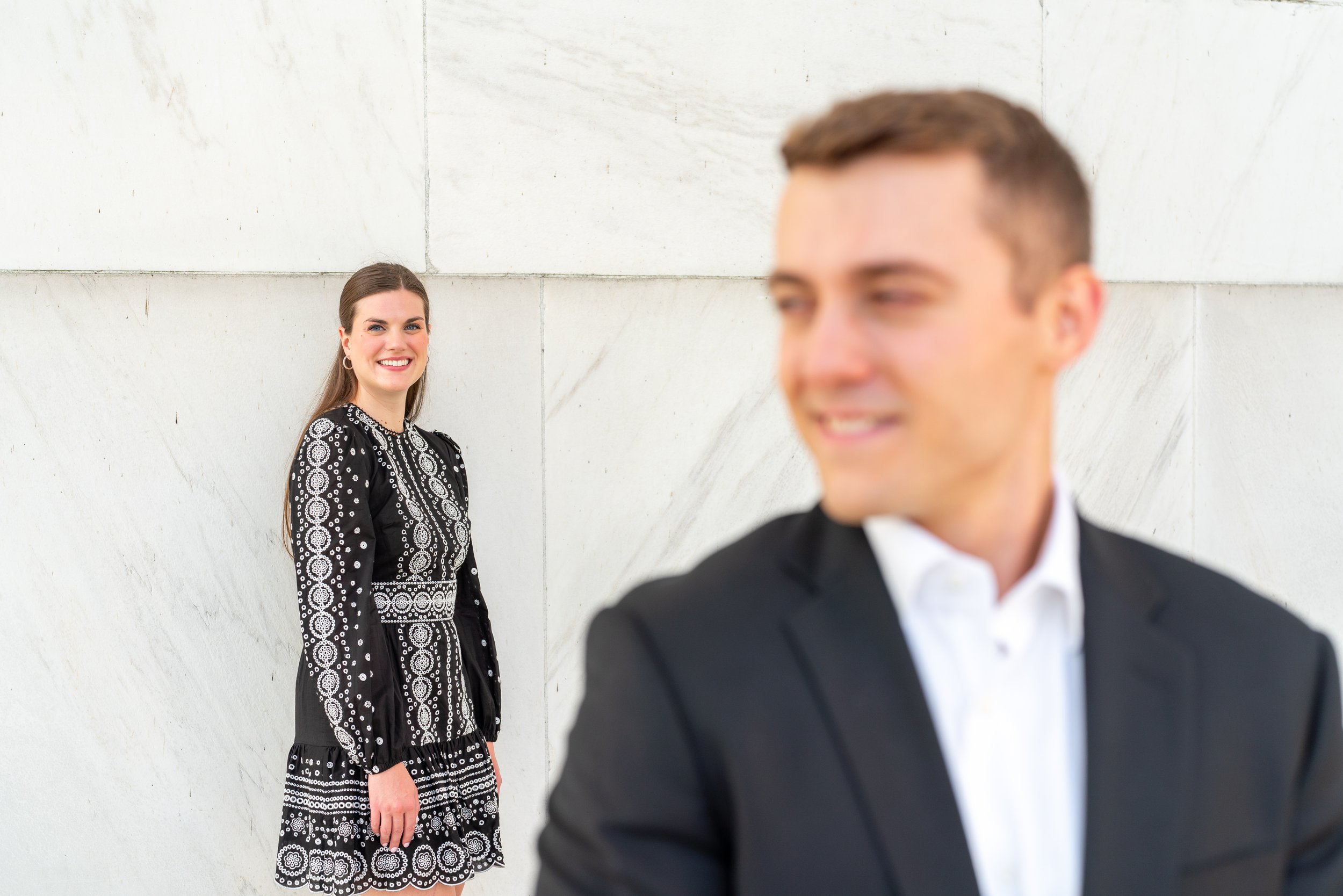 Groom looks over his shoulder at bride for engagement photos in DC