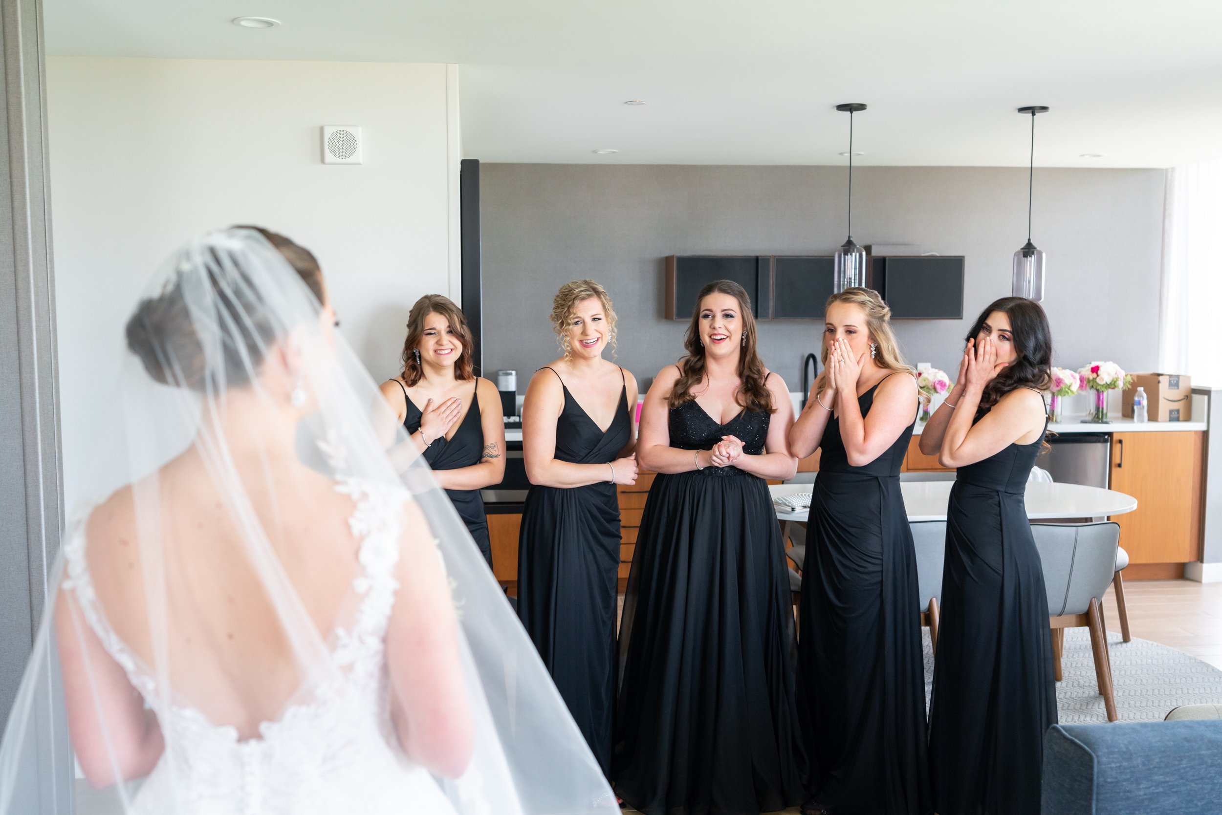 Candid reactions of bridesmaids seeing bride for first time
