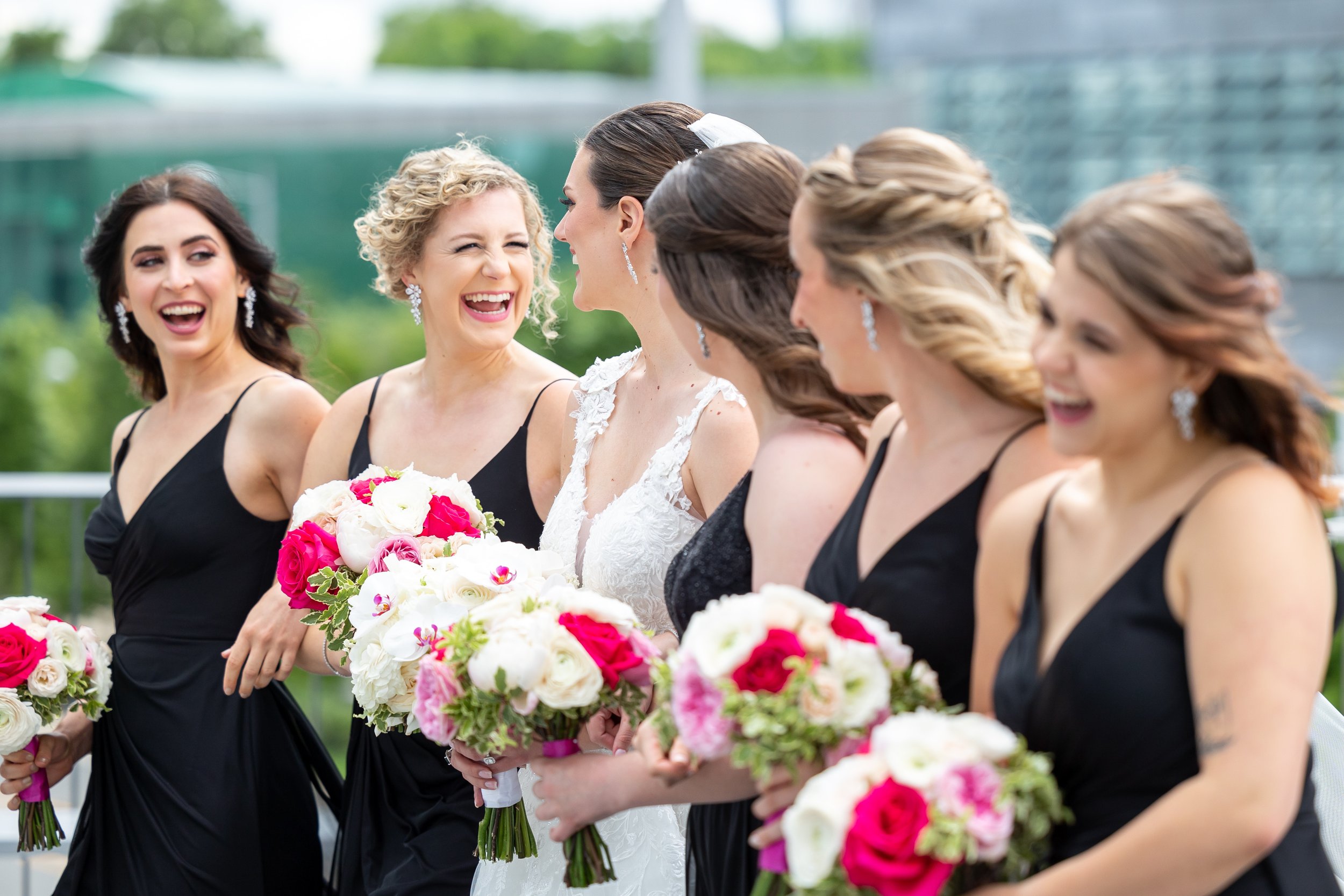Bridesmaids laughing with bride in candid wedding photos at Capital One Hall