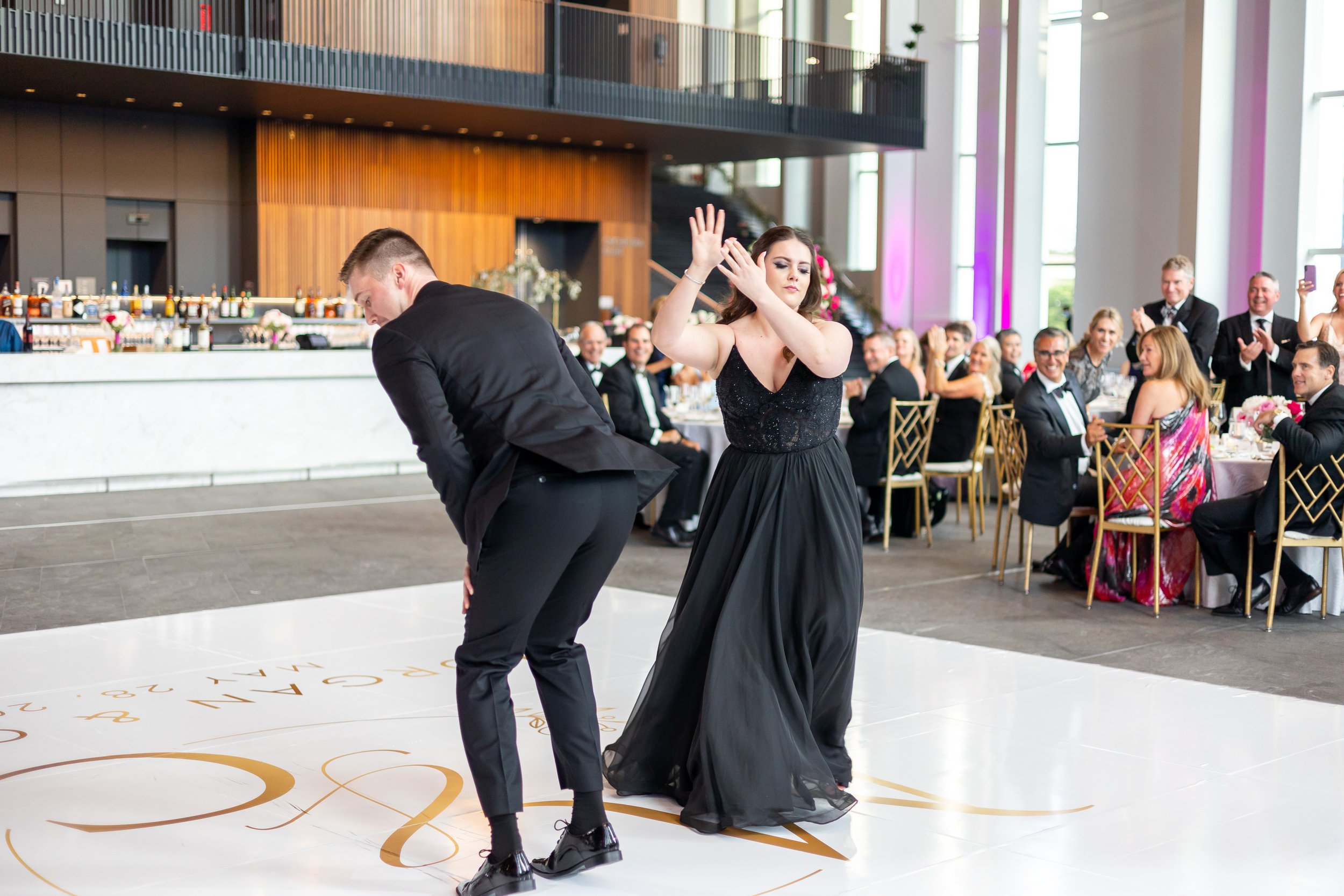 Bridesmaid and groomsmen dance on the monogrammed dance floor during wedding reception
