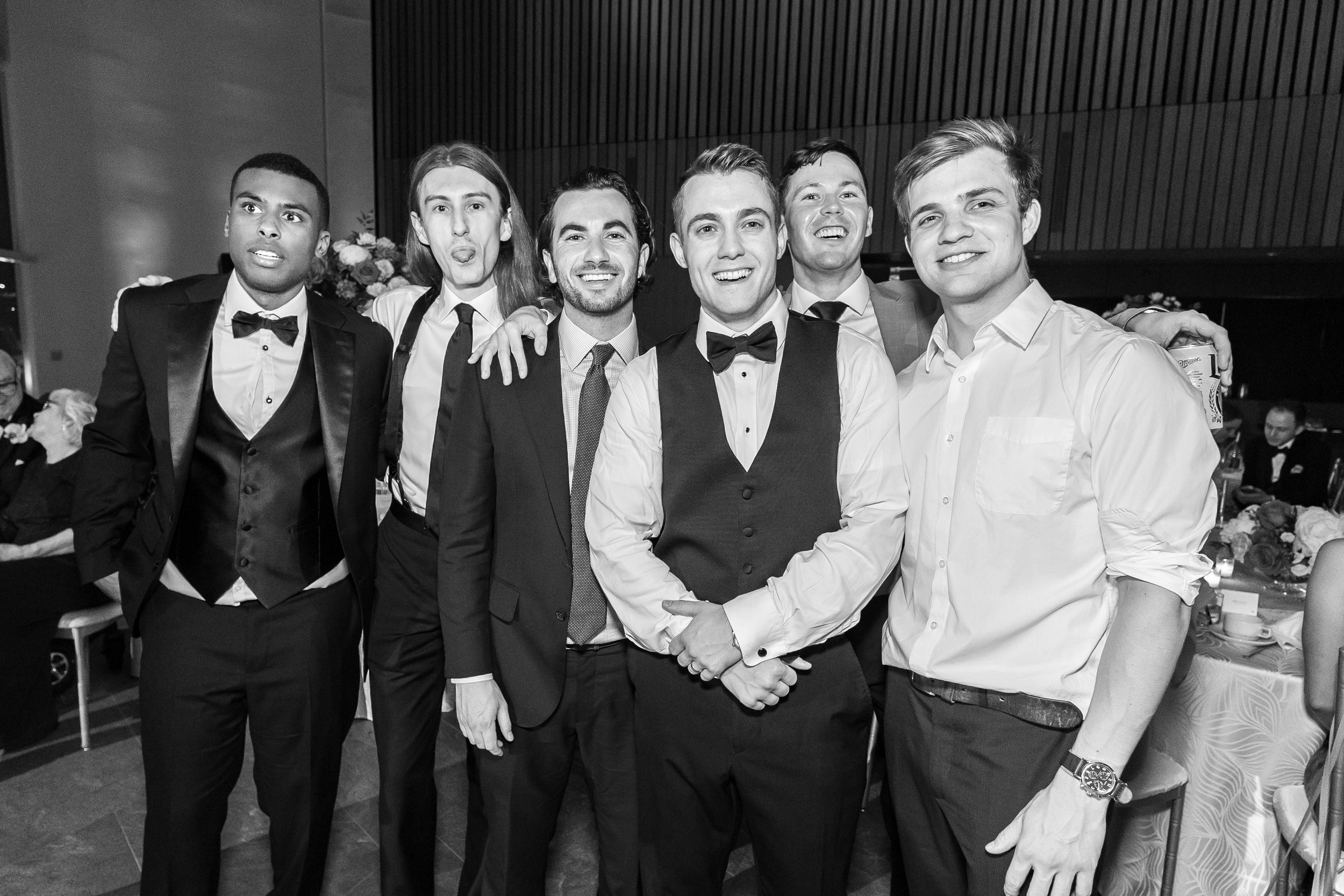 Groom and his friends pose for cool black and white portraits on the dance floor