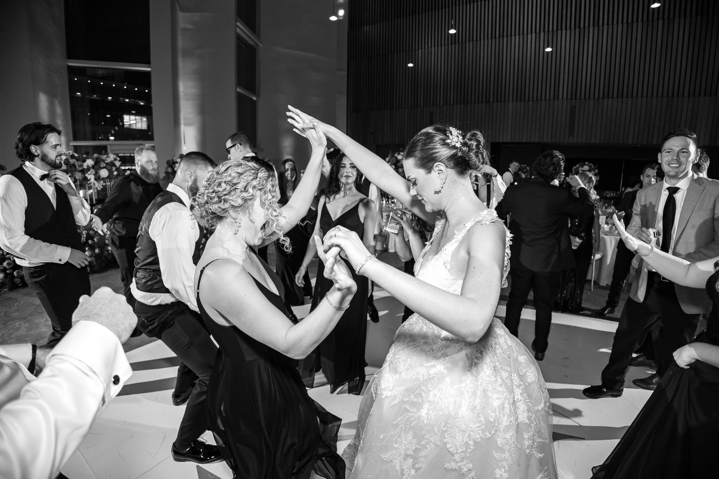 Bride and bridesmaid dance in chic black and white photo in Tyson's Virginia wedding venue