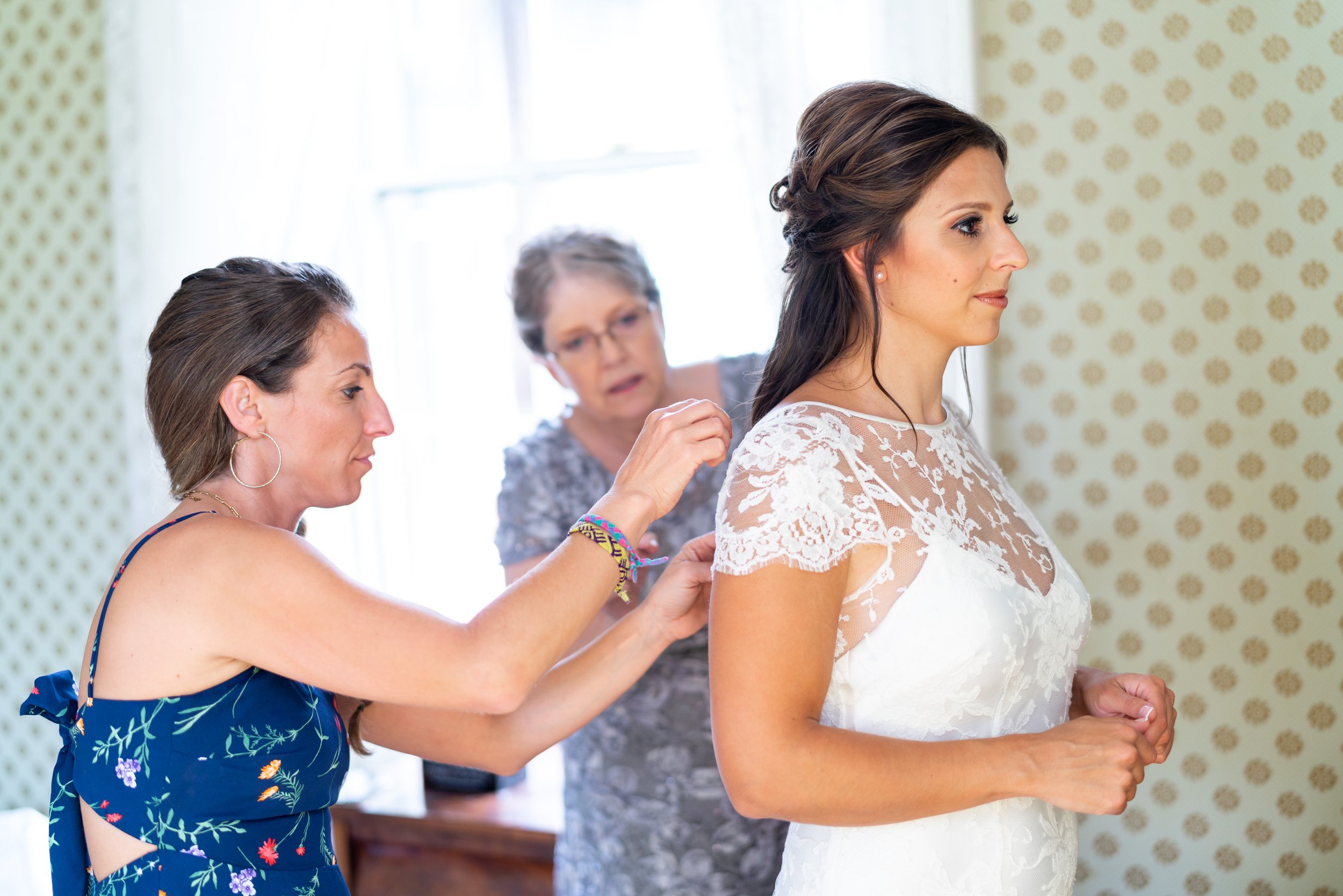 Bride being zipped up in bridal suite at Lincoln's Cottage wedding