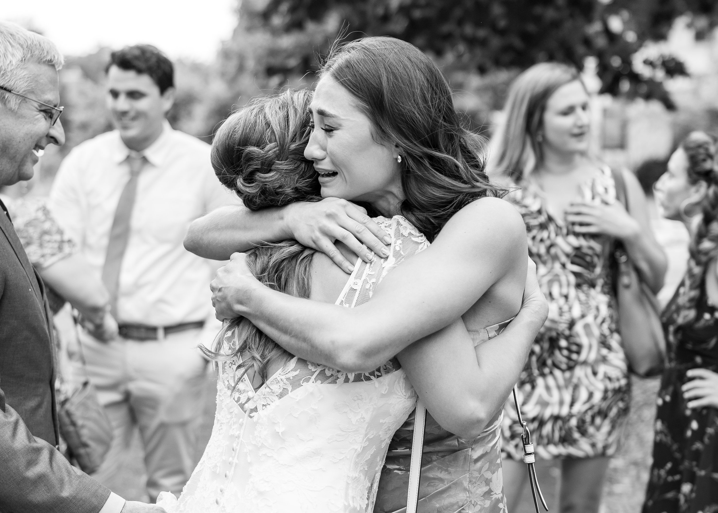 Friend hugging bride and crying after the wedding ceremony