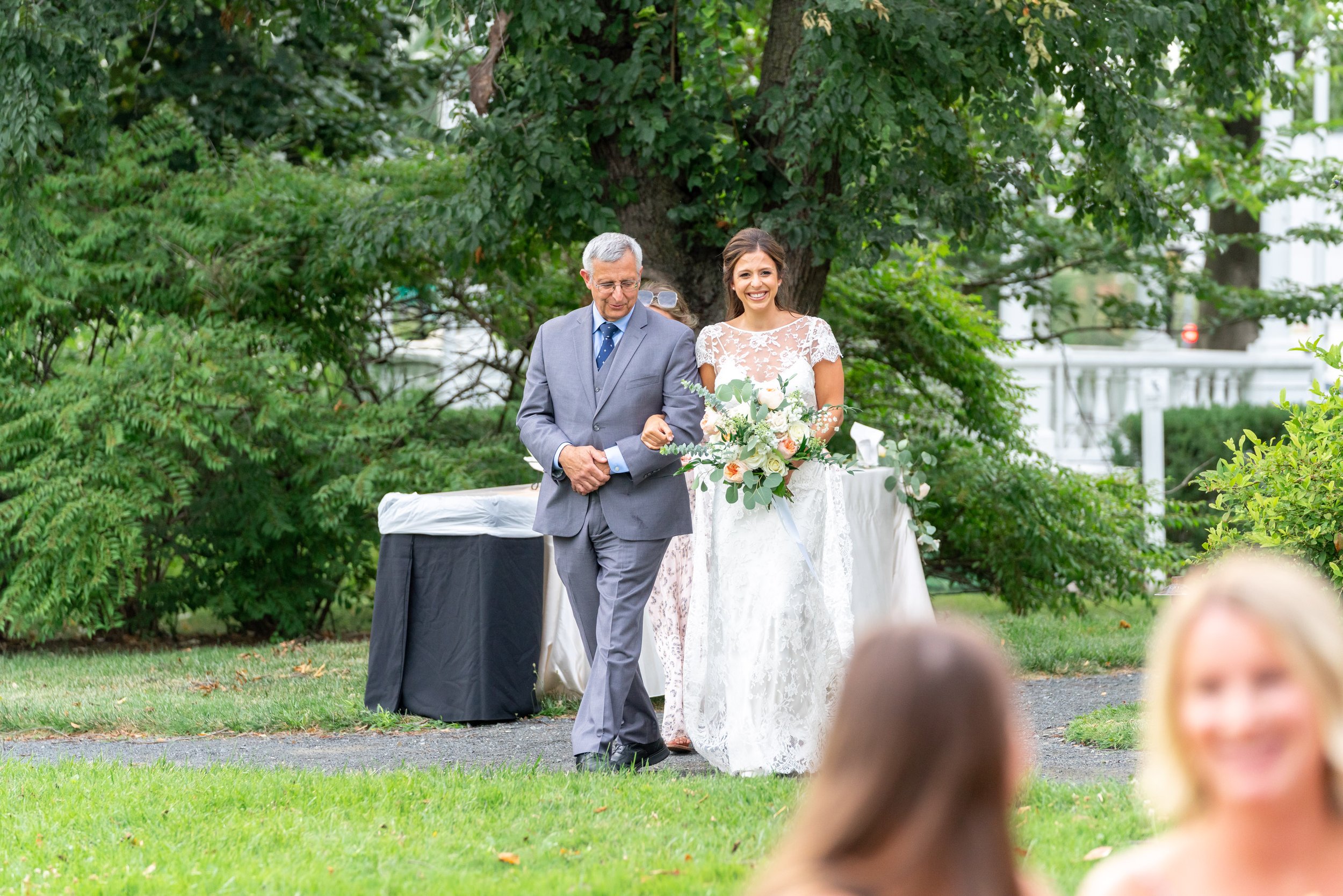 Bride walking down the aisle with her father in outdoor summer DC ceremony