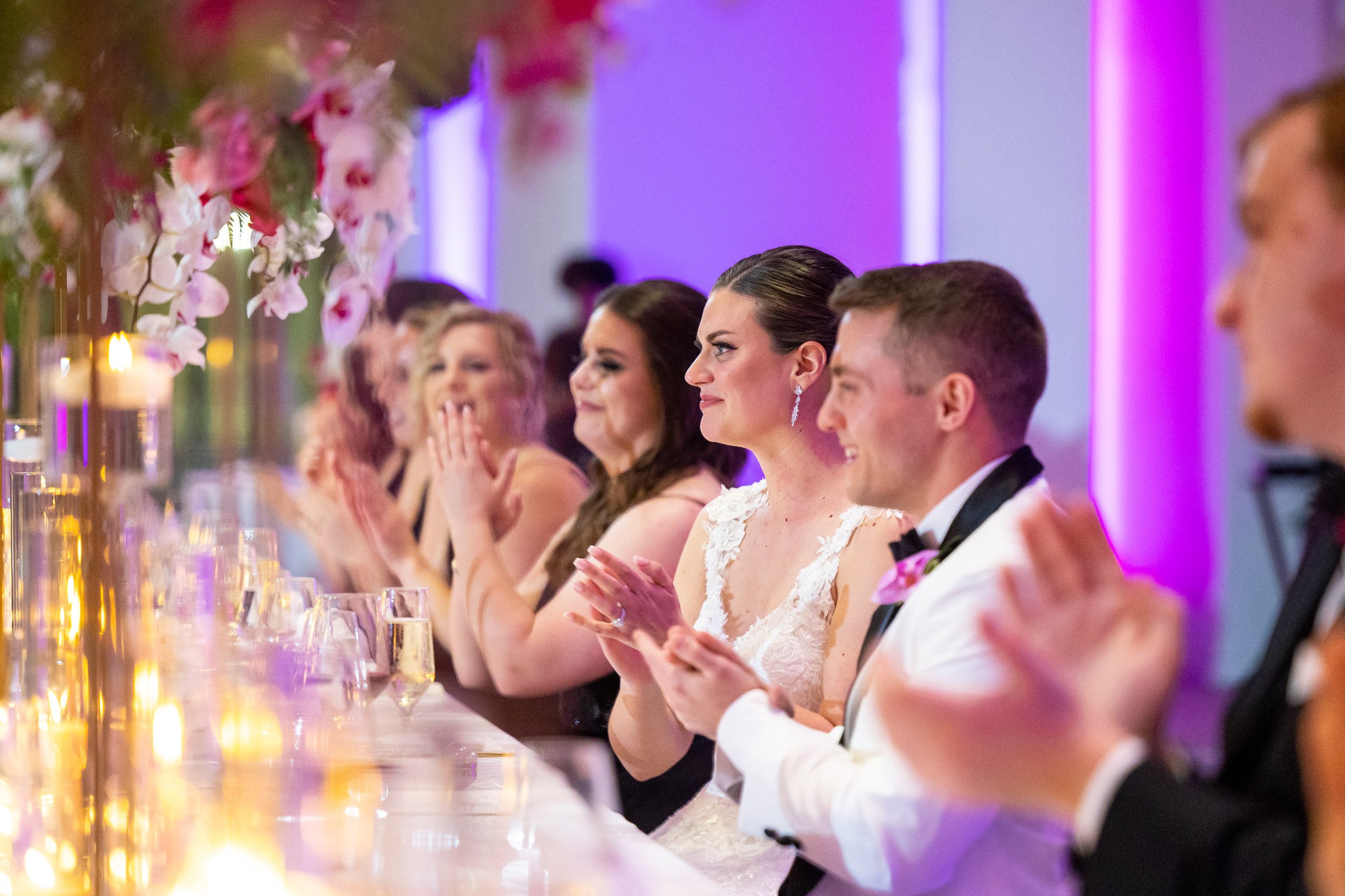 Couple and wedding party clap after toasts at Capital One Hall wedding