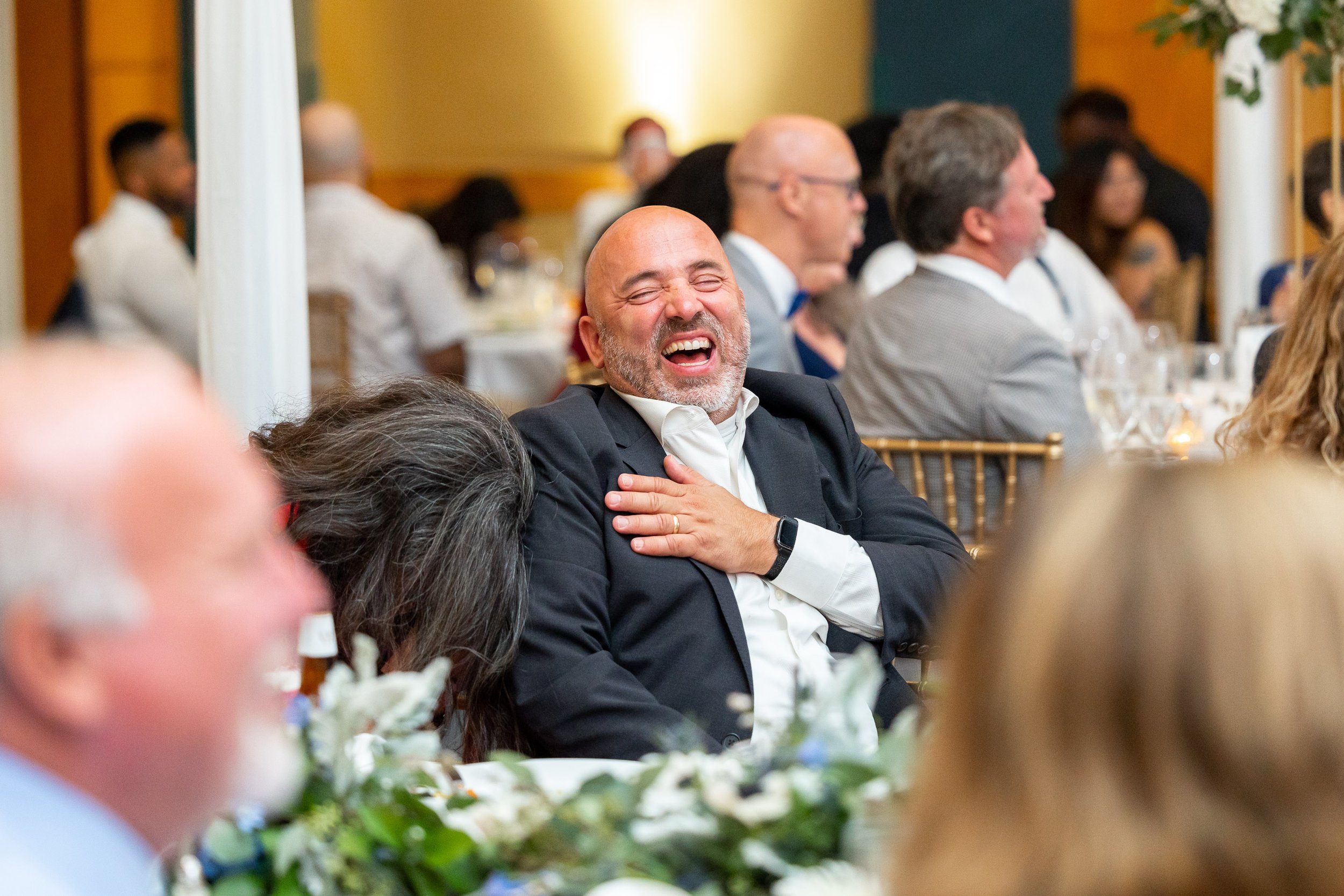 Guests laugh at the best man's funny speech to the groom