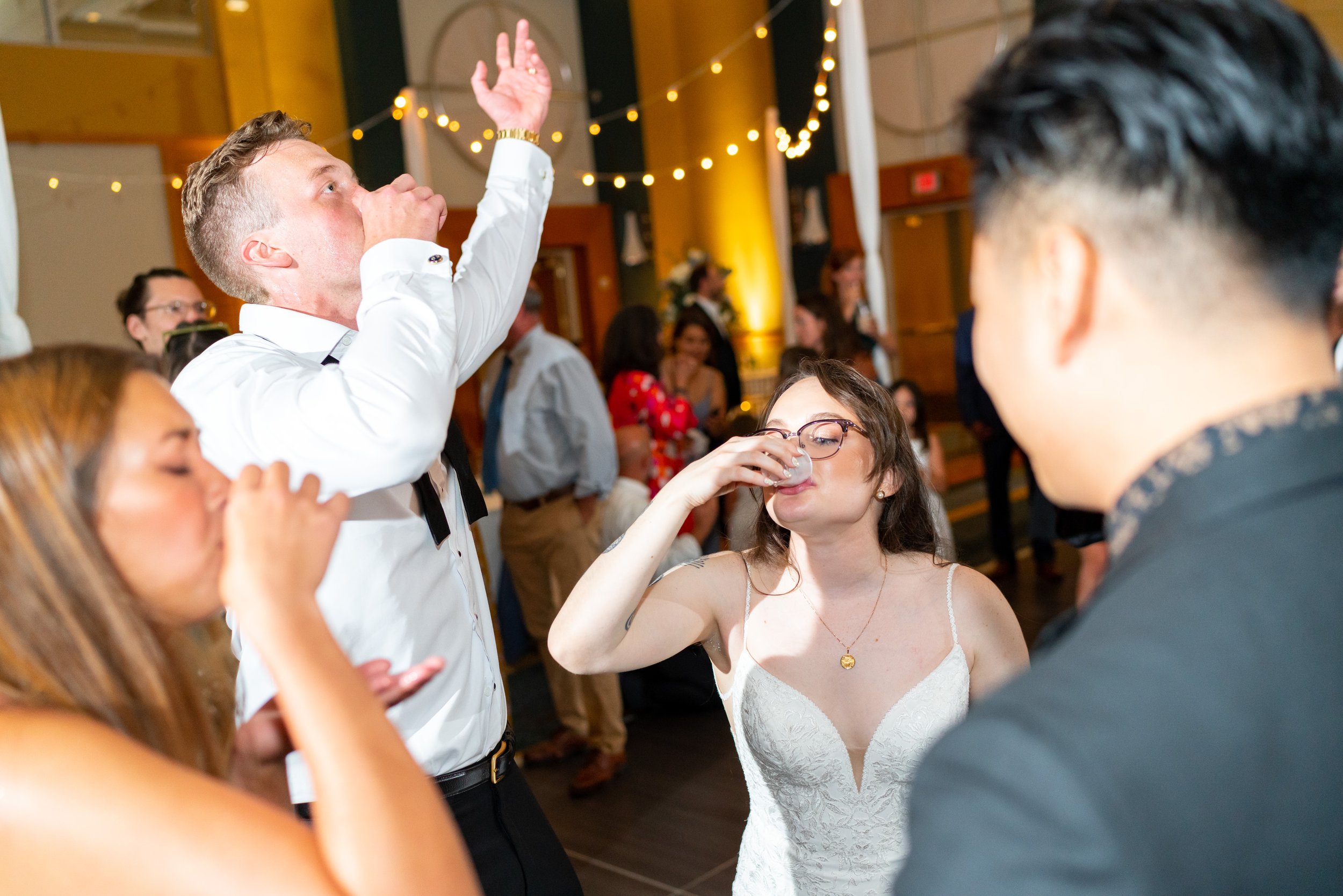bride and groom do shots on the dance floor during wedding reception photos