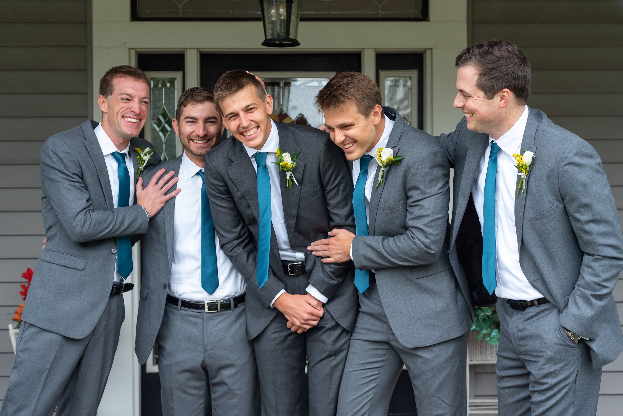 Groom and groomsmen laughing on front porch of Luray Virginia airbnb