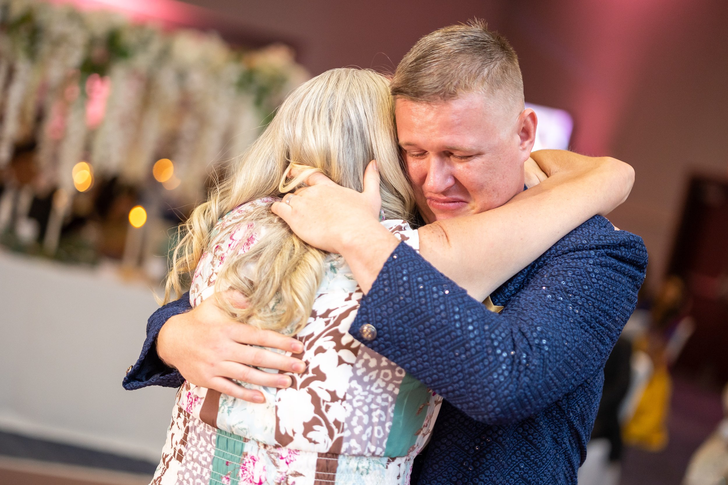 groom hugs his mother during mother son dance 