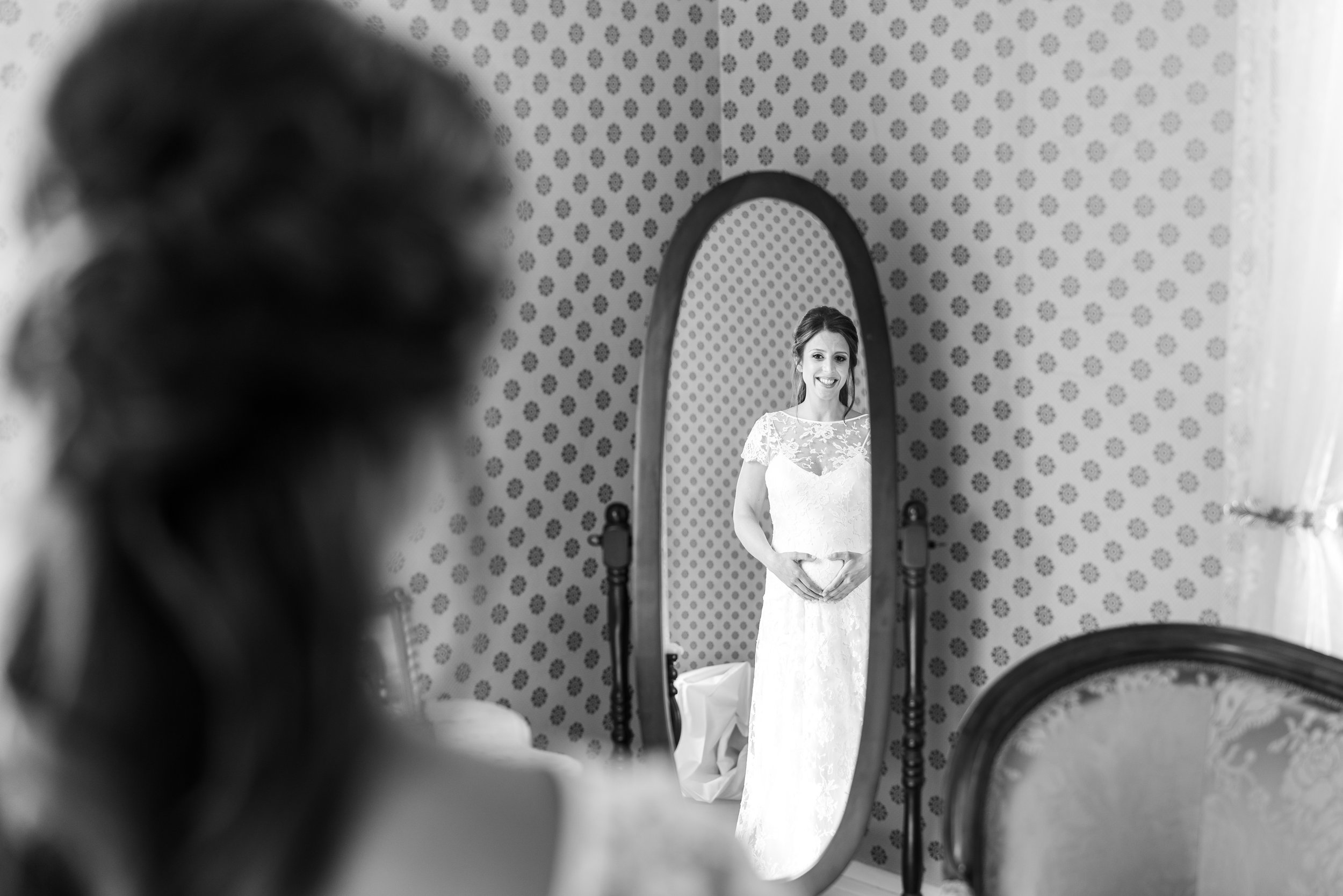 Bride looking in mirror upstairs in bridal suite at President Lincoln's Cottage wedding