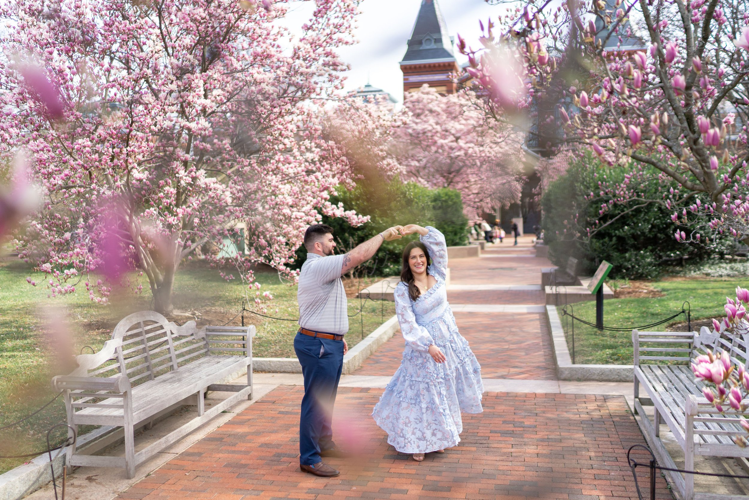 Groom twirling his bride at the Enid A Haupt garden with magnolias