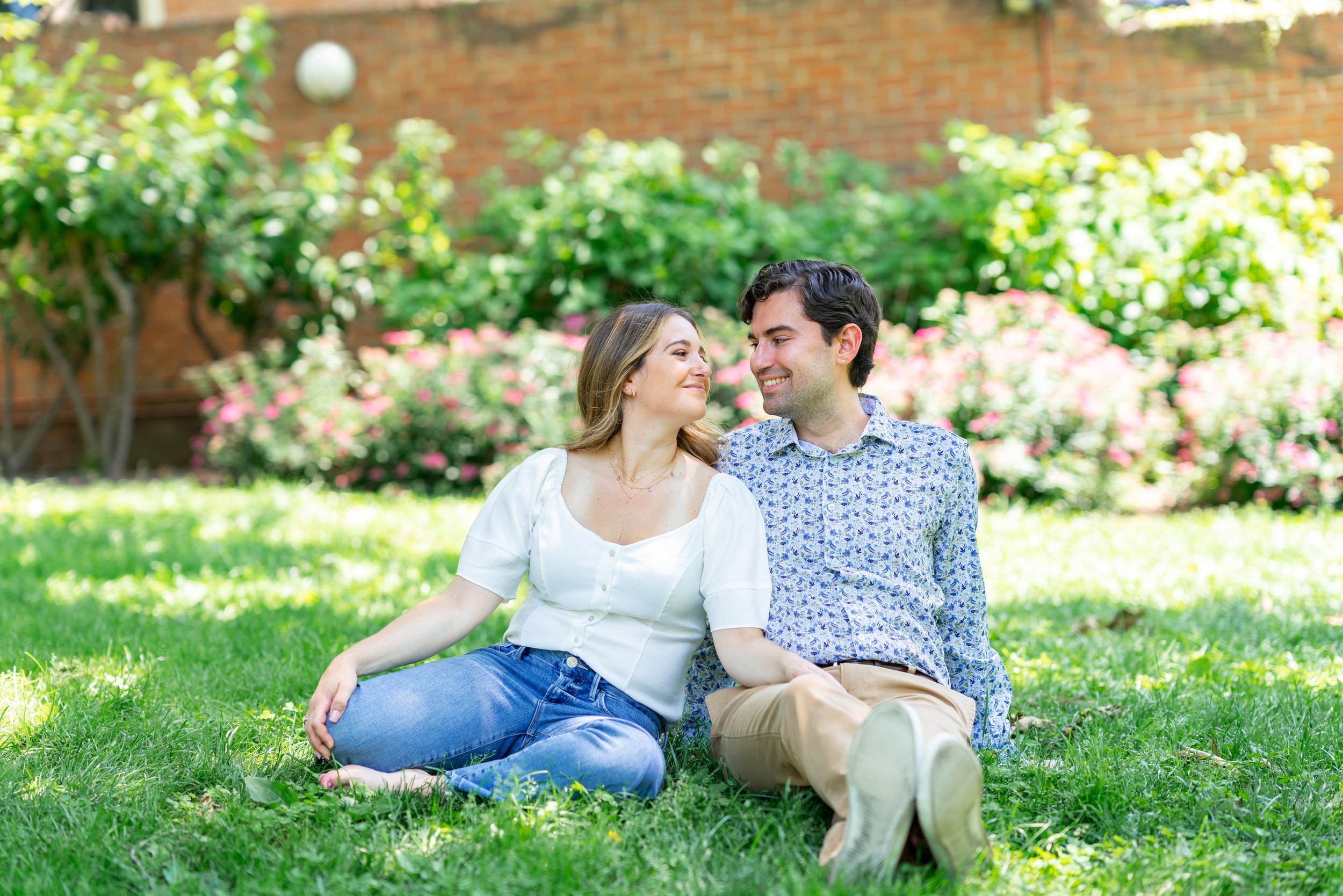 Couple sits in the grass for picnic at Mitchell Park in Washington DC engagement