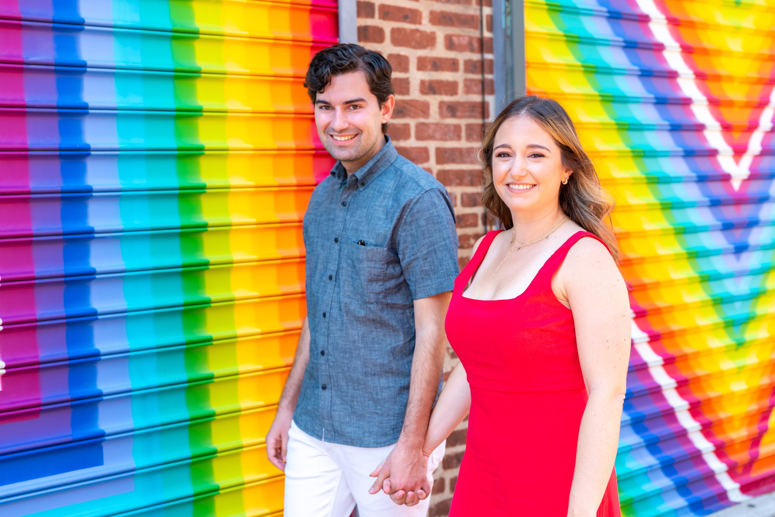 Couple walking by rainbow wall in Blagden Alley DC