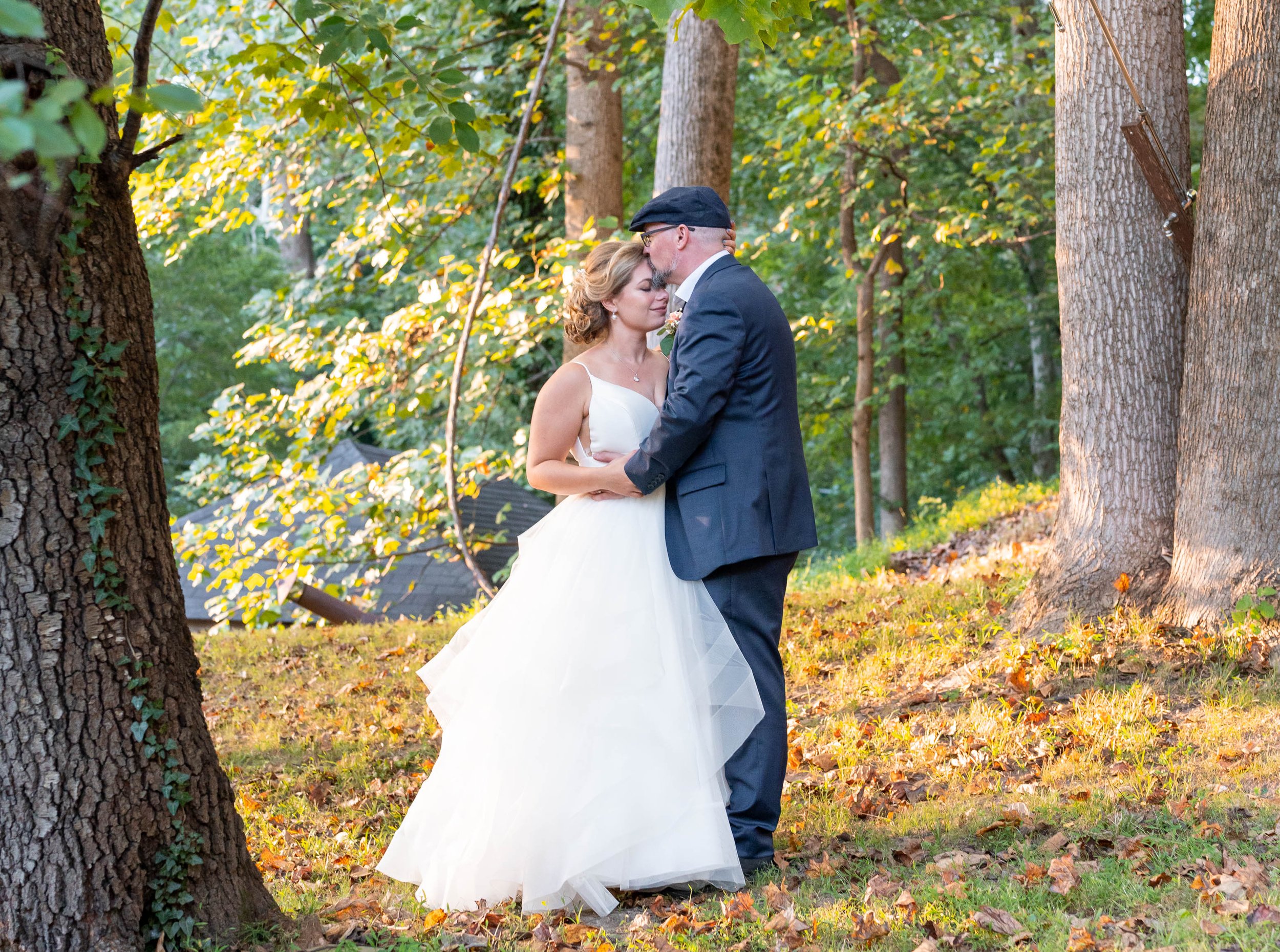 Bride and groom pose in fall trees at wedding at Old Angler's Inn