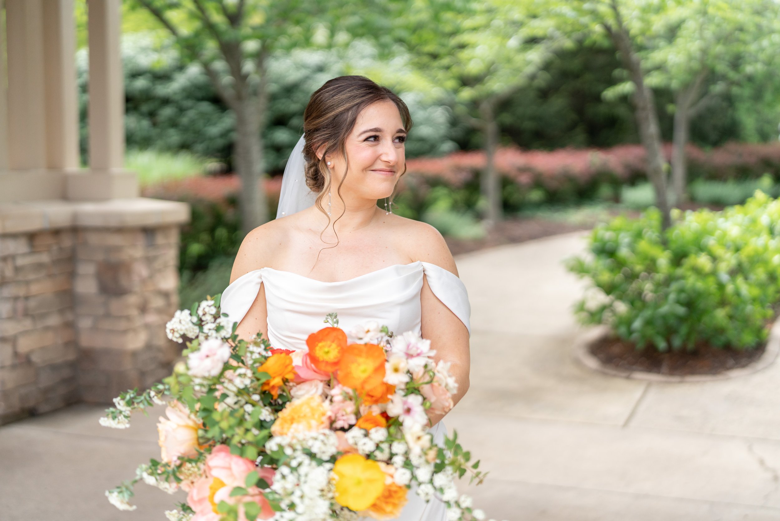 Bride with orange and peach bouquet with artichoke wedding flowers