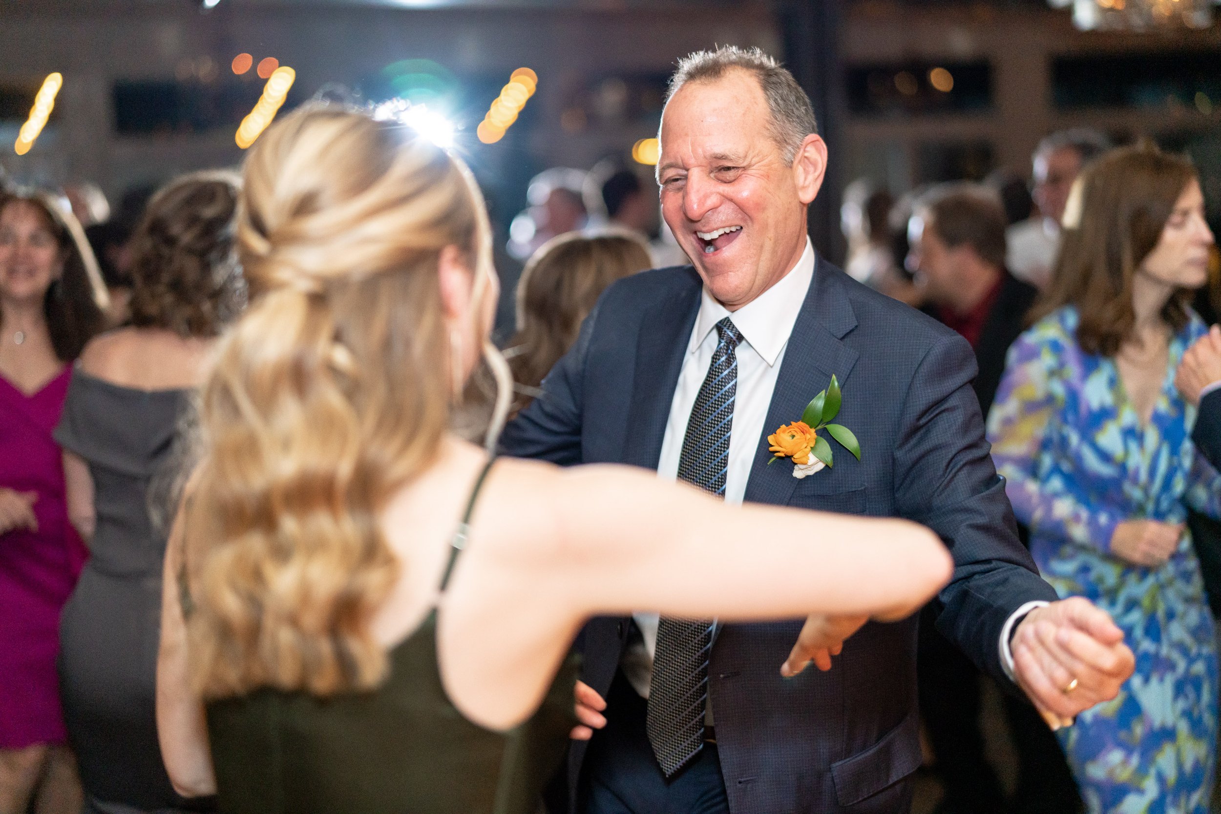 Father of the bride dancing with daughter in green bridesmaid dress