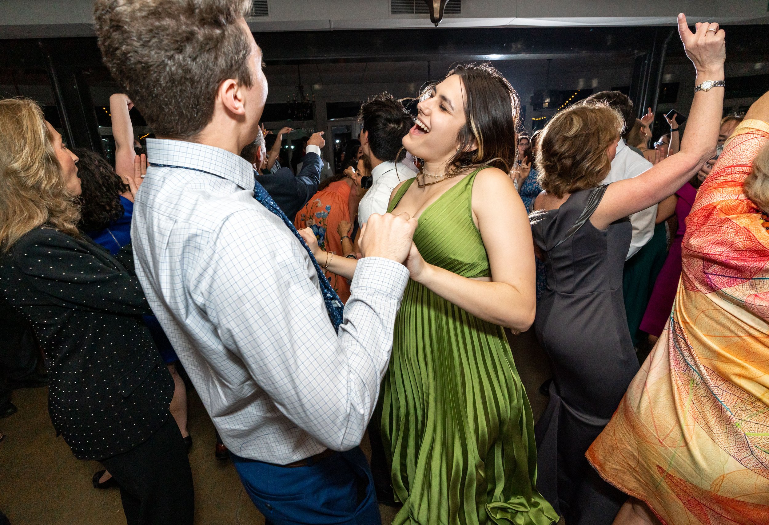 Guests smiling and dancing on the dance floor at Stone Tower Winery wedding