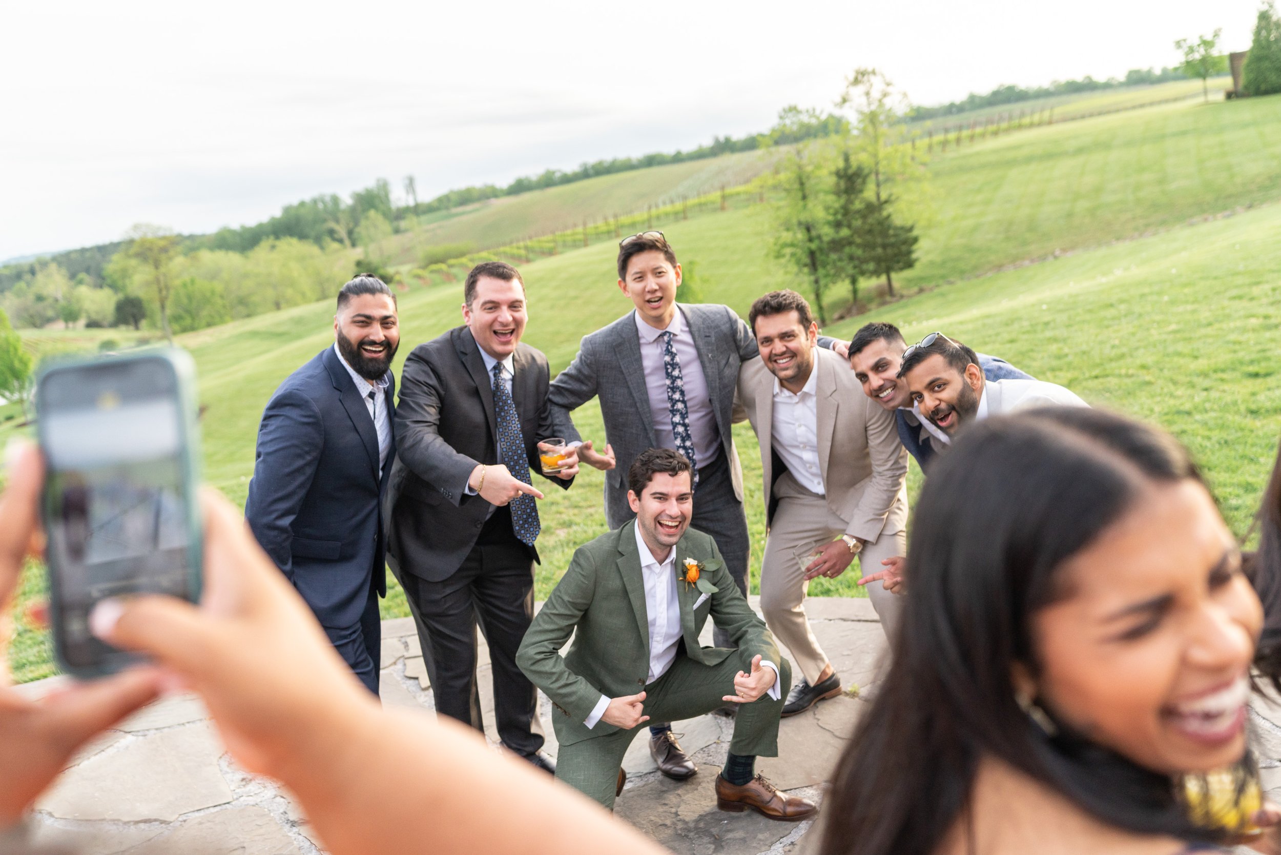 Groom poses with his friends for a photo during cocktail hour