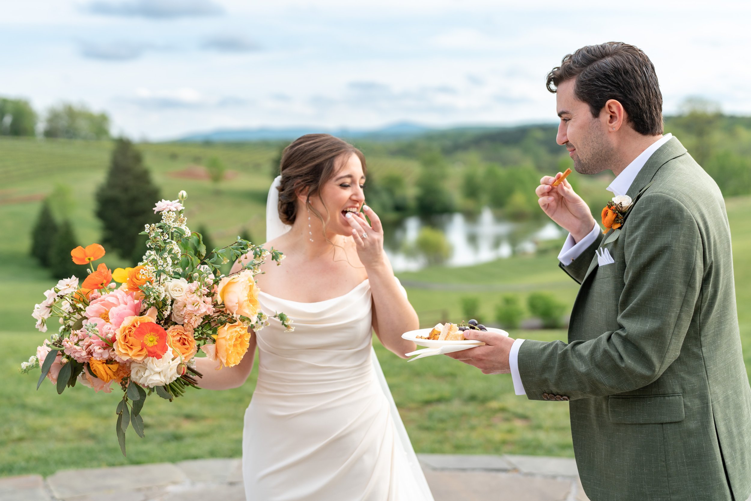 Bride and groom sneak hors d'oeuvres at Stone Tower Winery before the ceremony