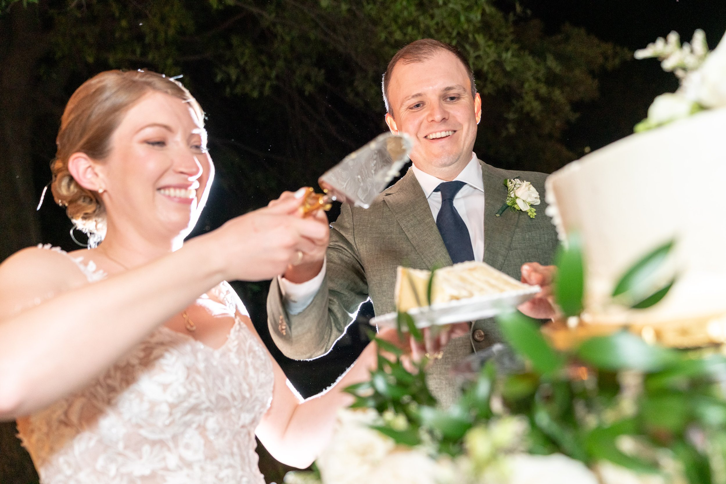 night time cake cutting photos with bride and groom at Lincoln's Cottage under tent