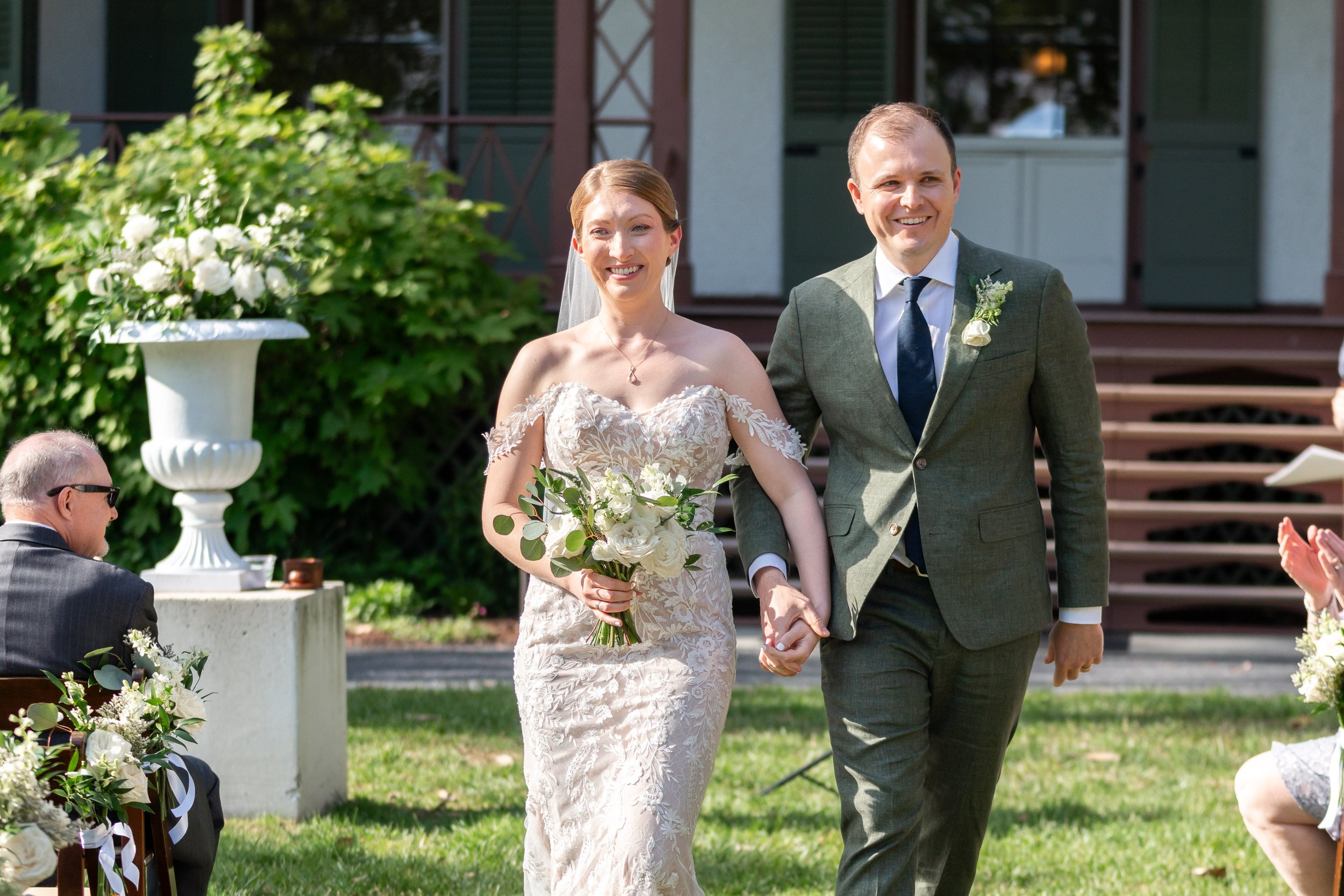 Bride and groom recessional summer lawn aisle at Lincoln's Cottage
