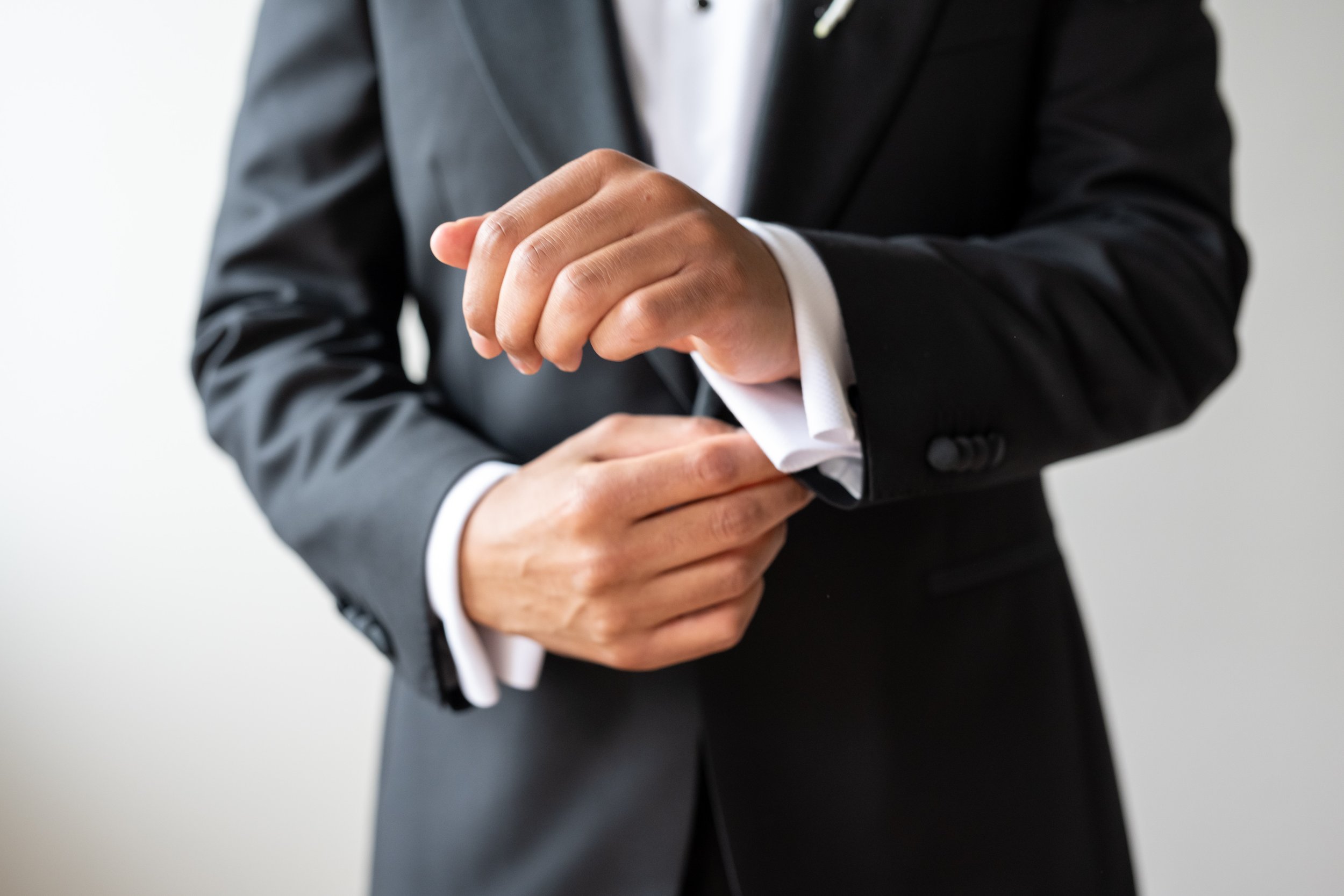 Groom adjusts his cuff links in grooms suite at Vignon Manor Farm