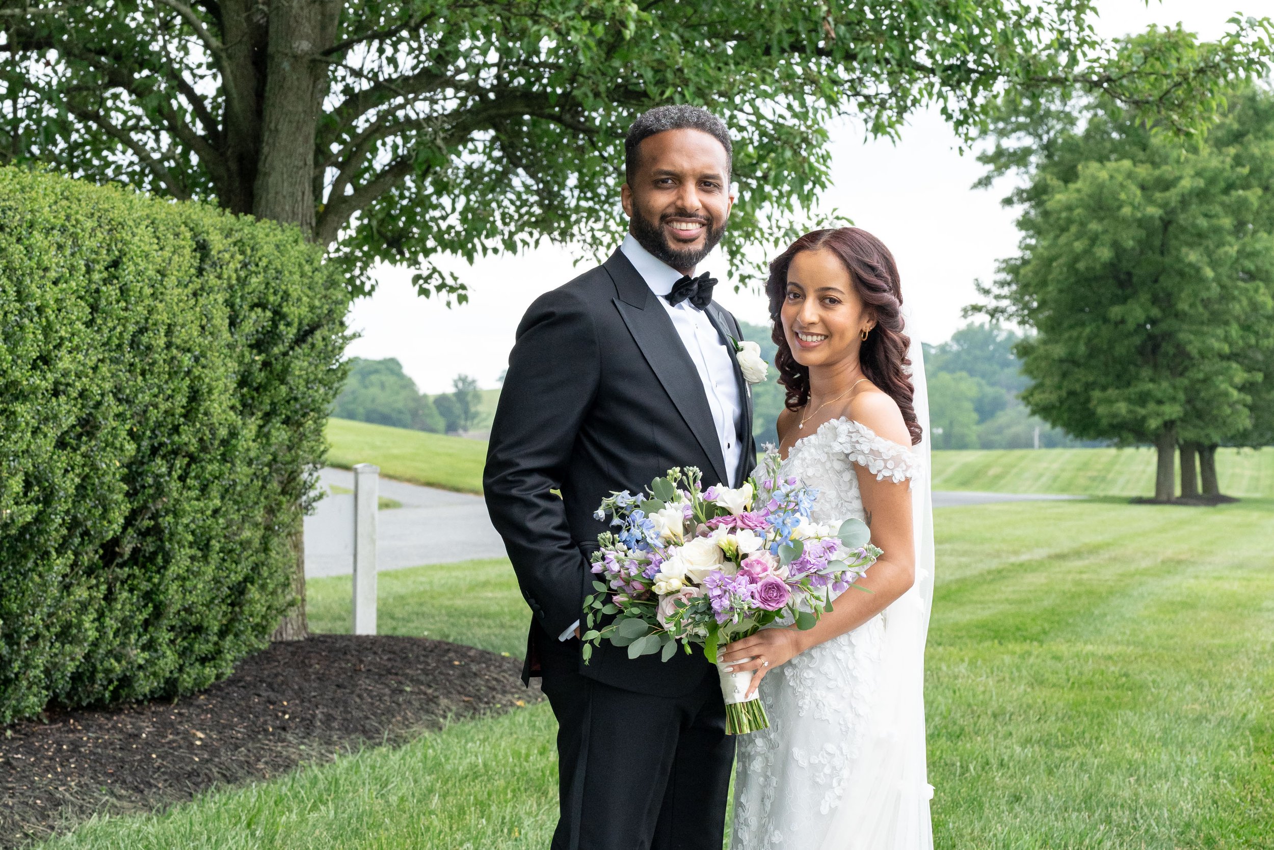 Bride and groom pose for camera outside in Baltimore area wedding