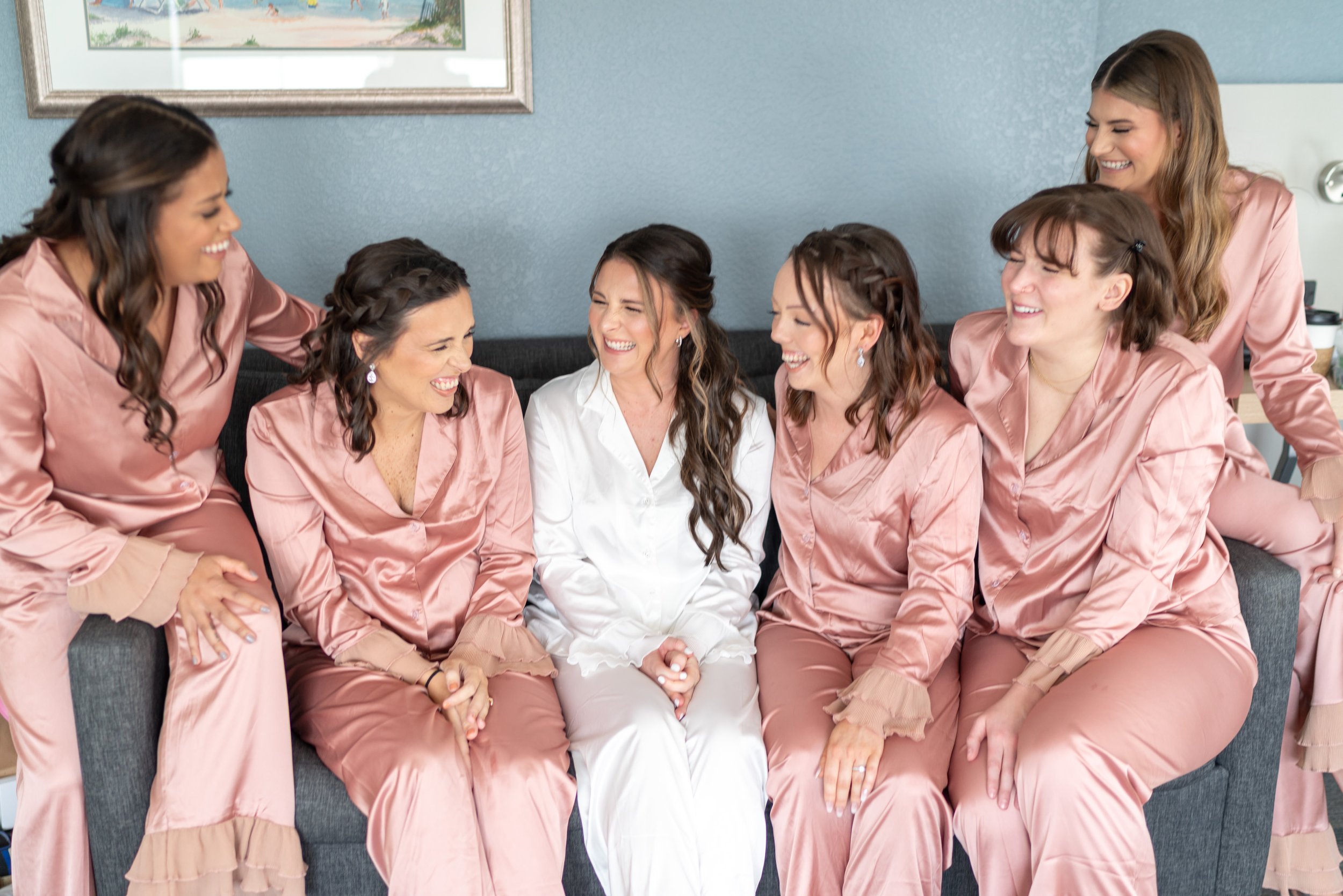 Bride and bridesmaids in pink satin pajamas on wedding day
