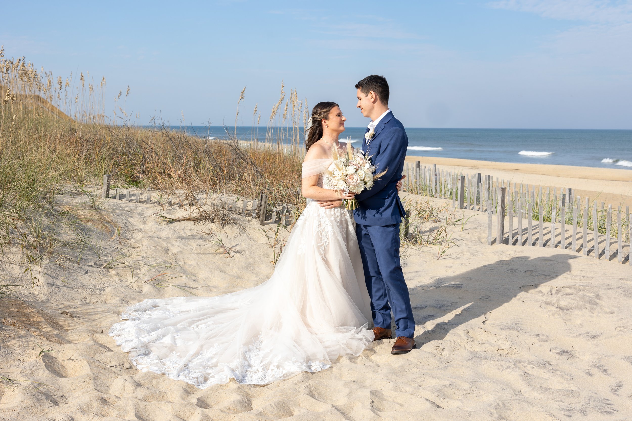 Bride and groom photos in sand on Kitty Hawk Pier wedding photos