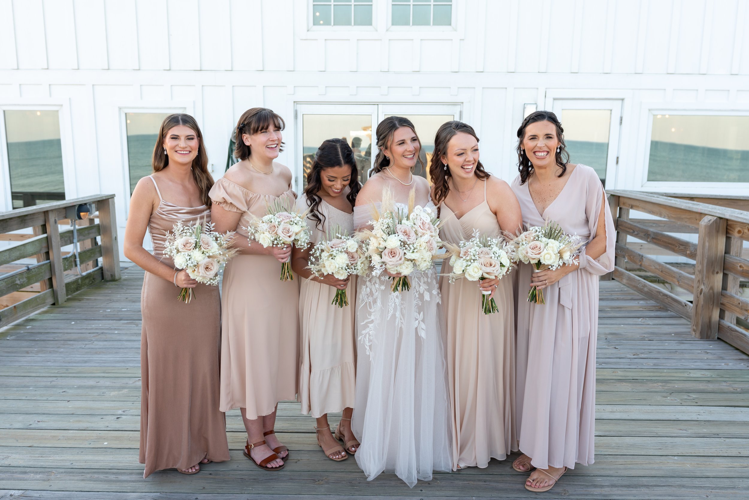 Bridesmaids in mix and match pink at Kitty Hawk Pier wedding
