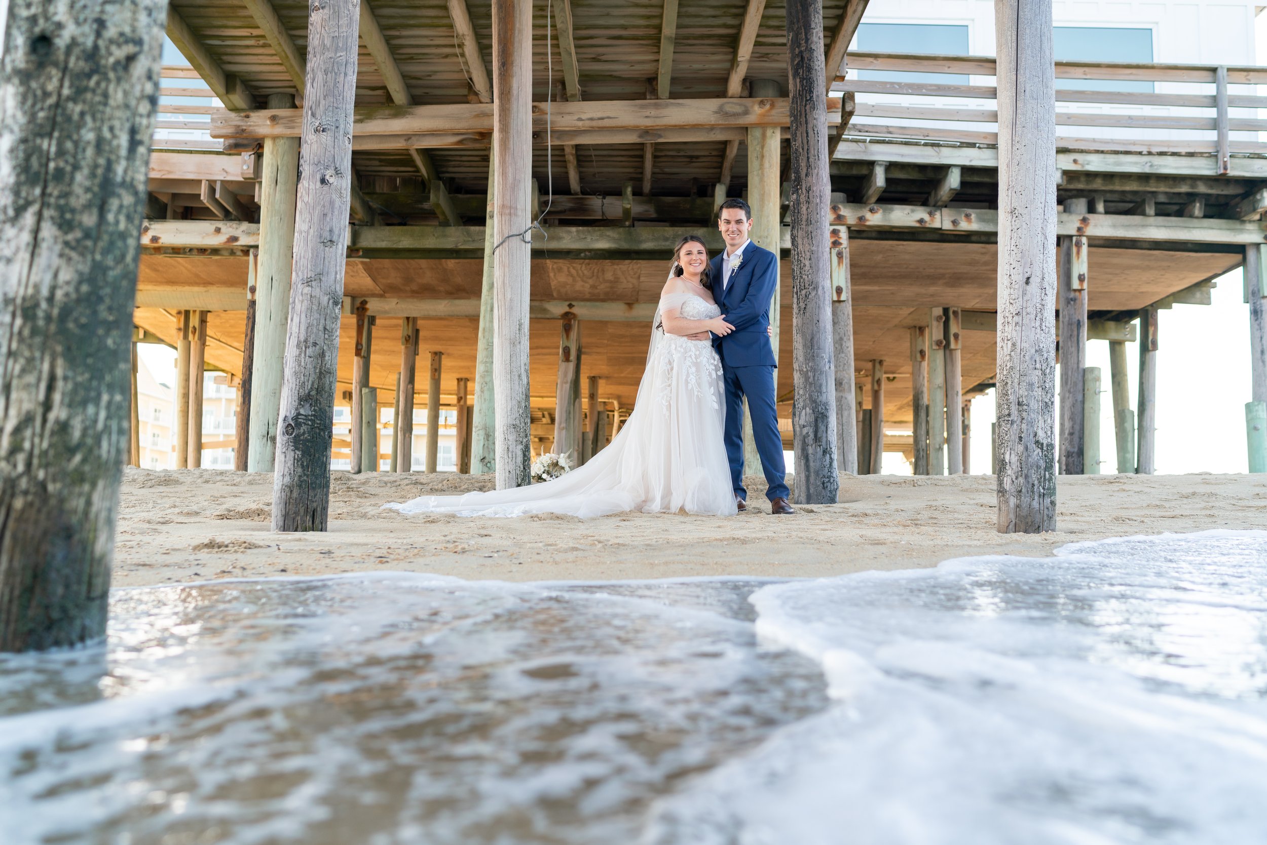 Kitty Hawk Pier photos under pier bride and groom in the water Outer Banks wedding