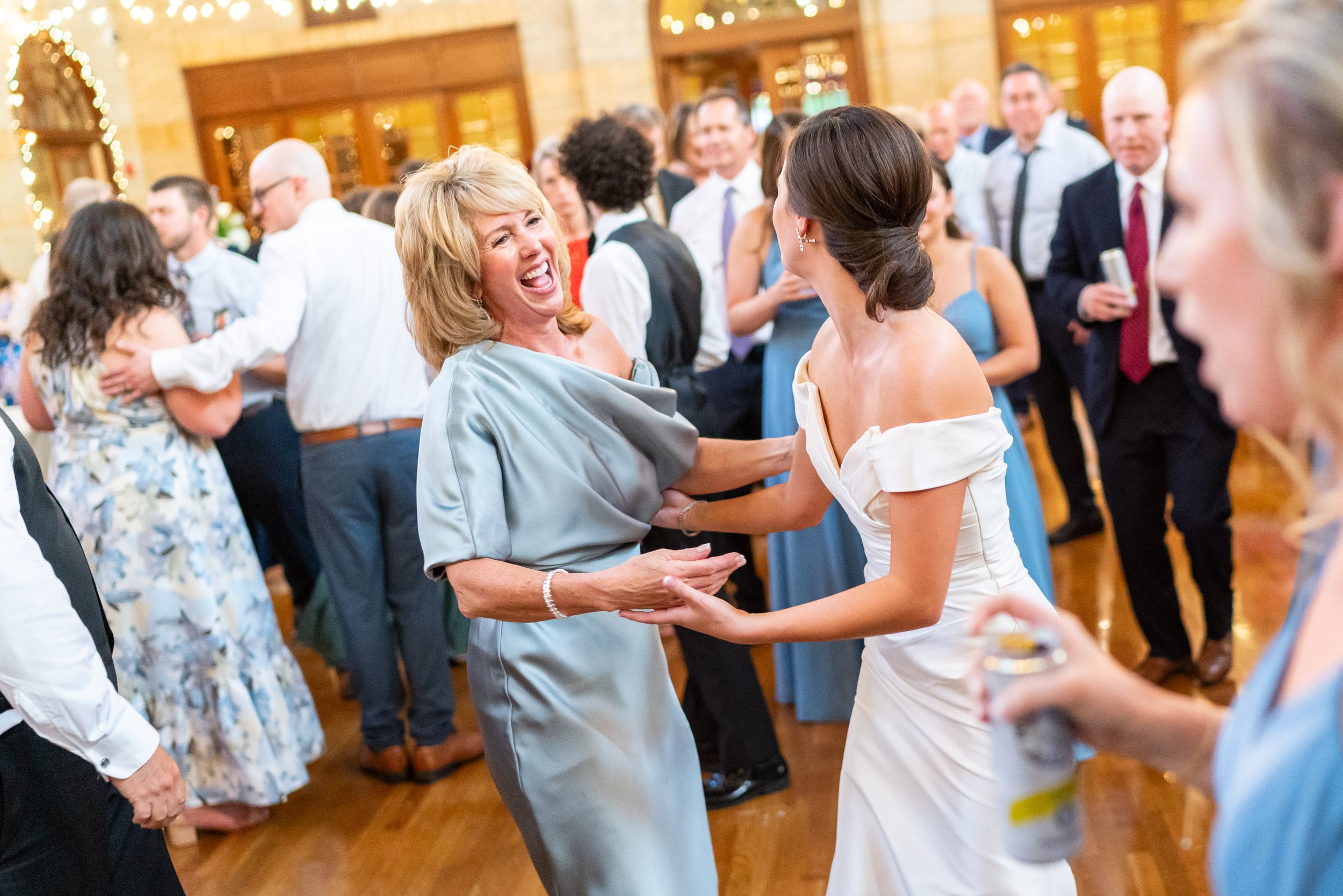 Bride dances with Mother of the groom at fun wedding photos at St Francis Hall