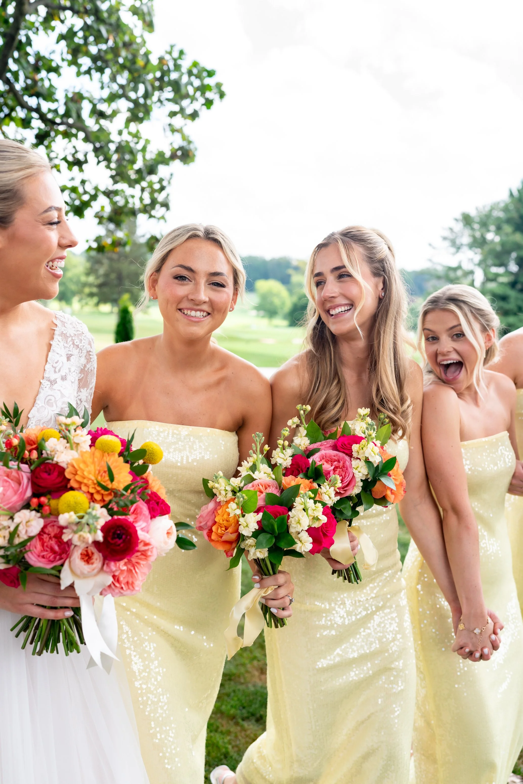 Bridesmaids smiling and holding hands at wedding at Manor Country Club