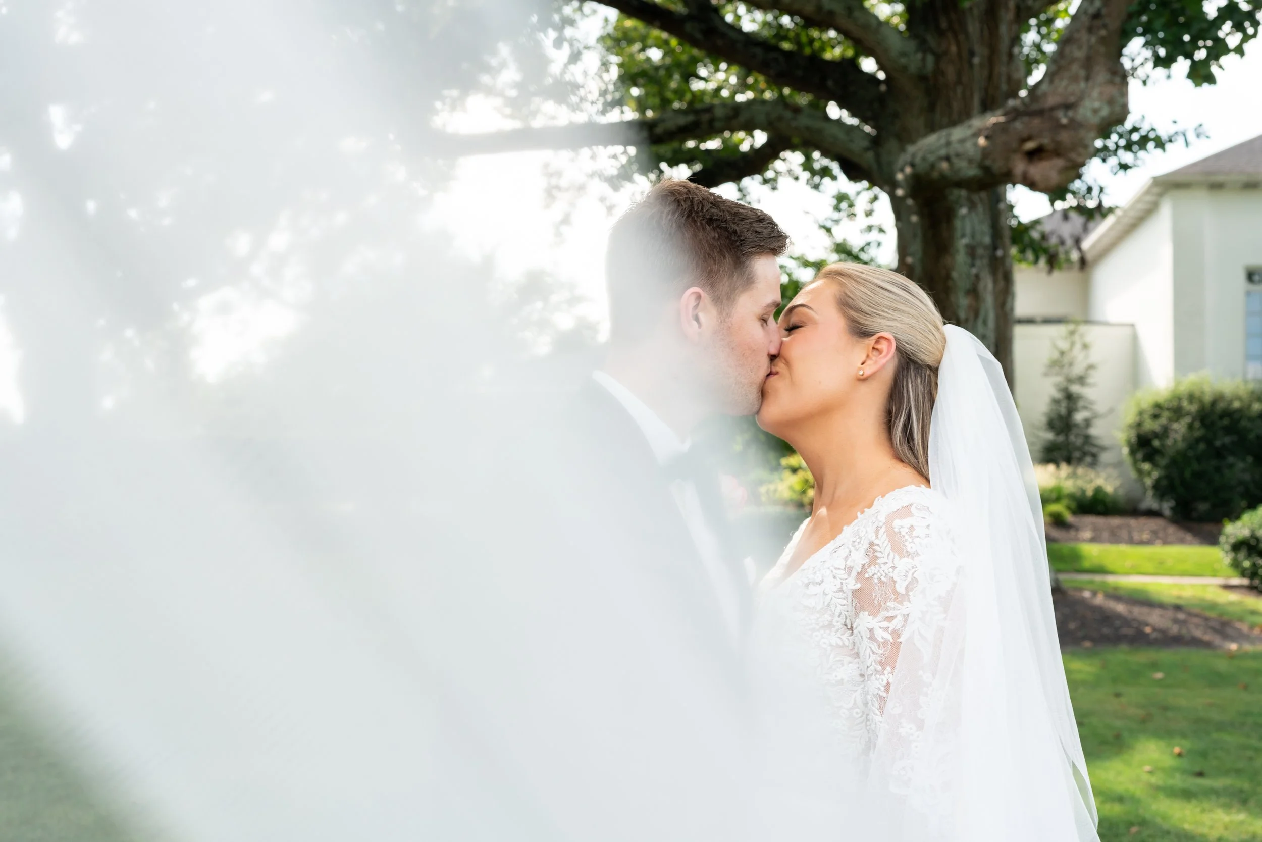Bride and groom kissing veil shot at Manor Country Club wedding