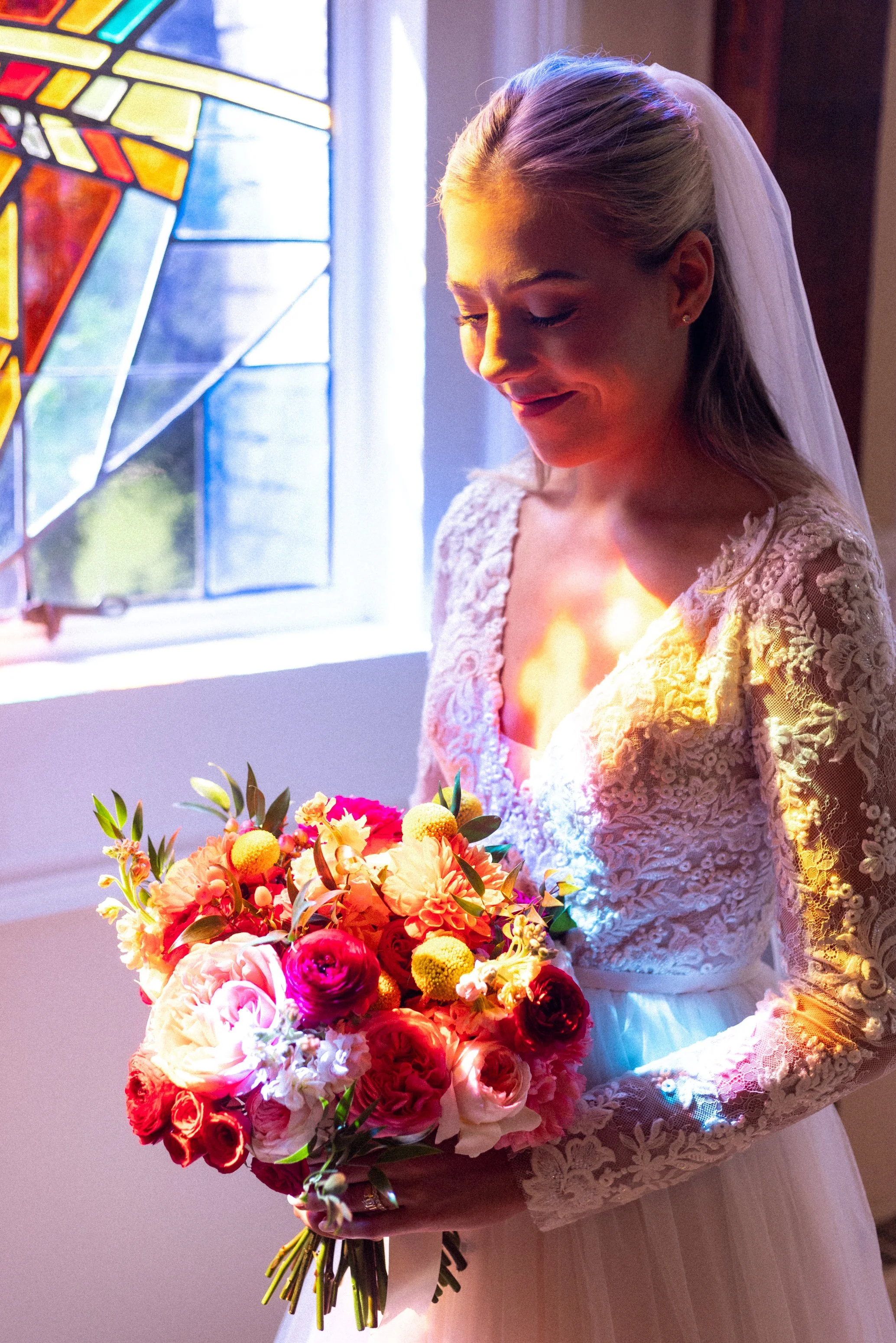 Bride in stained glass light at St Patrick's Catholic Church in Rockville Maryland wedding