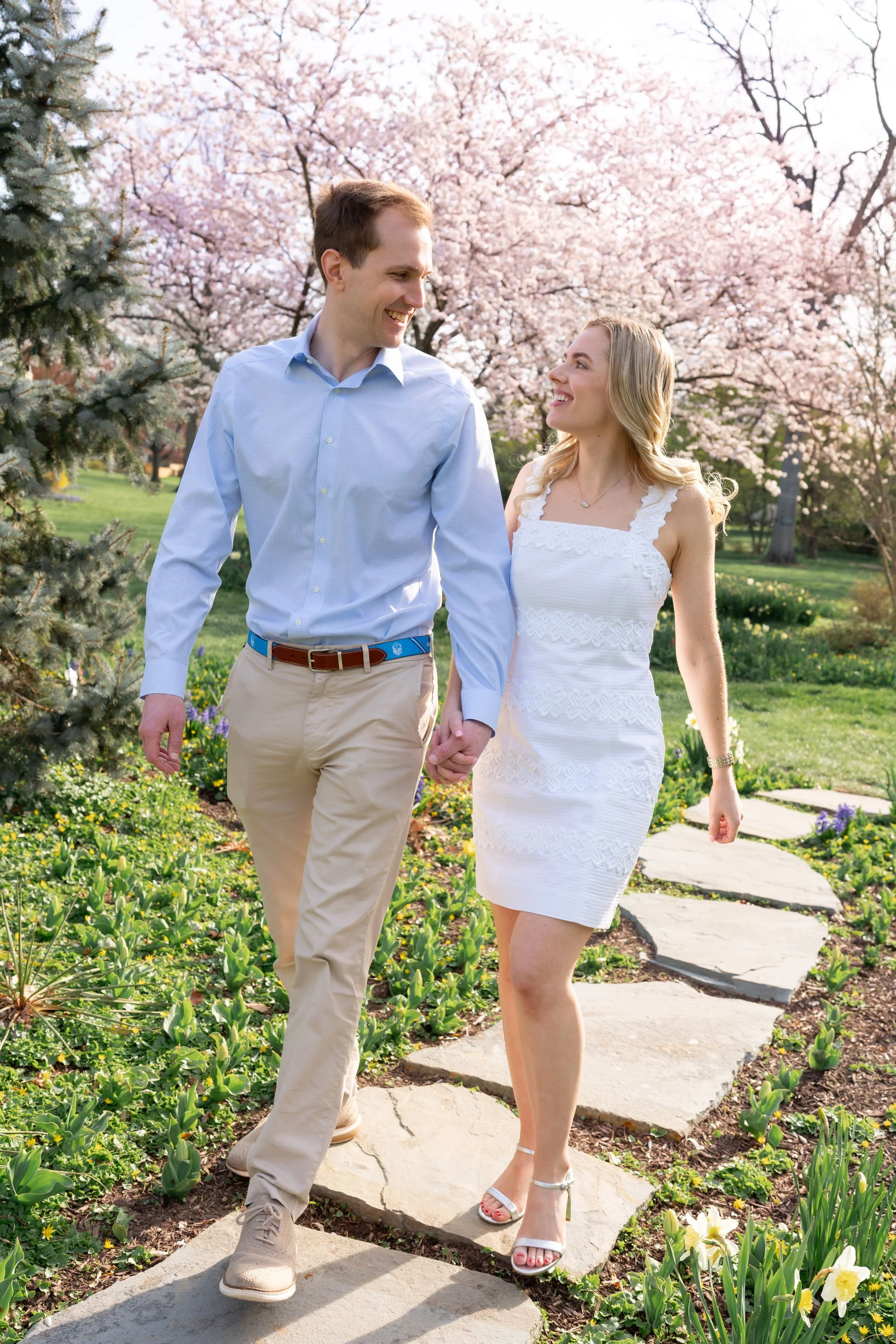 Bride and groom walking through gardens and cherry blossoms in Bethesda maryland