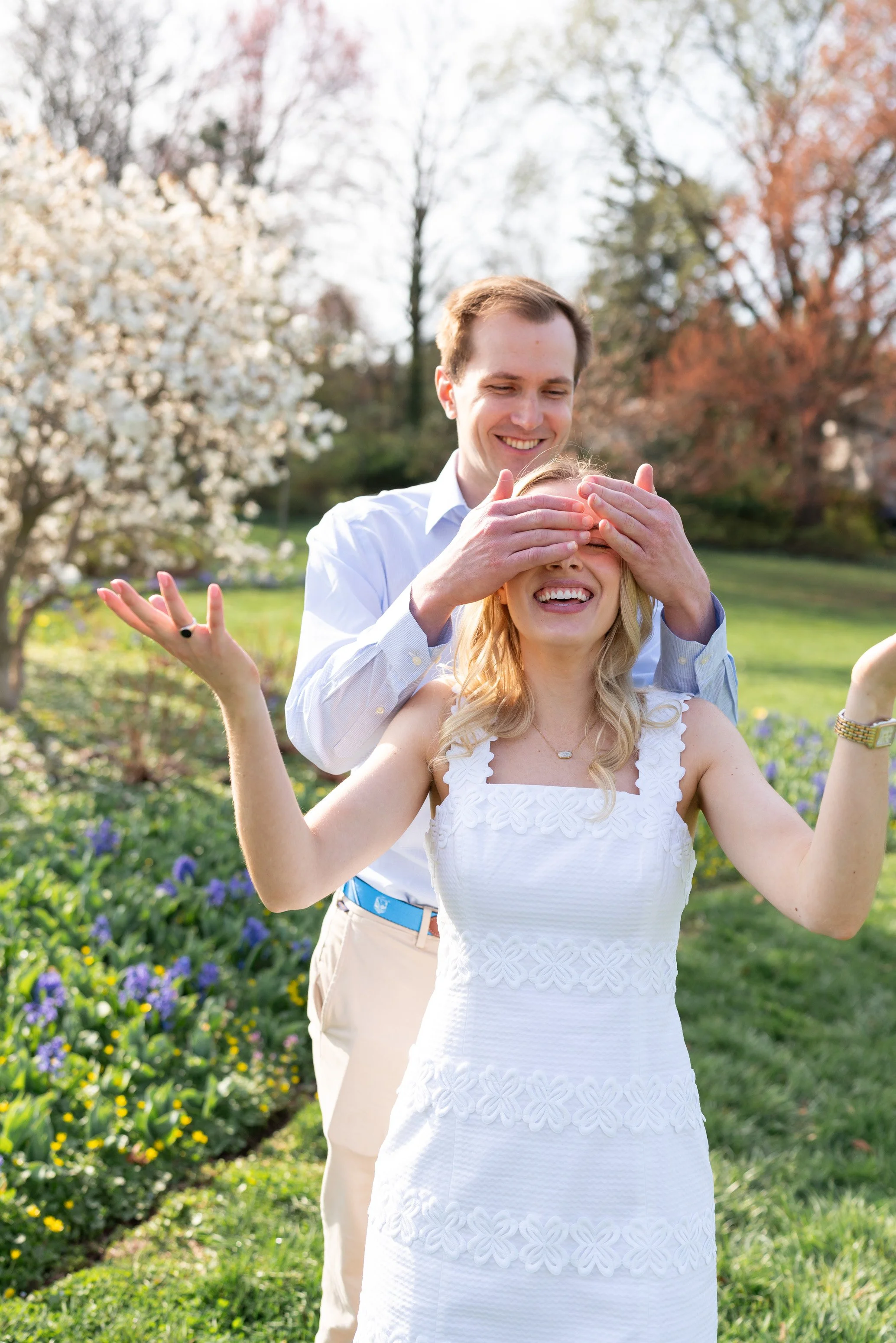 fun and natural spring engagement photos with cherry blossoms and flowering trees