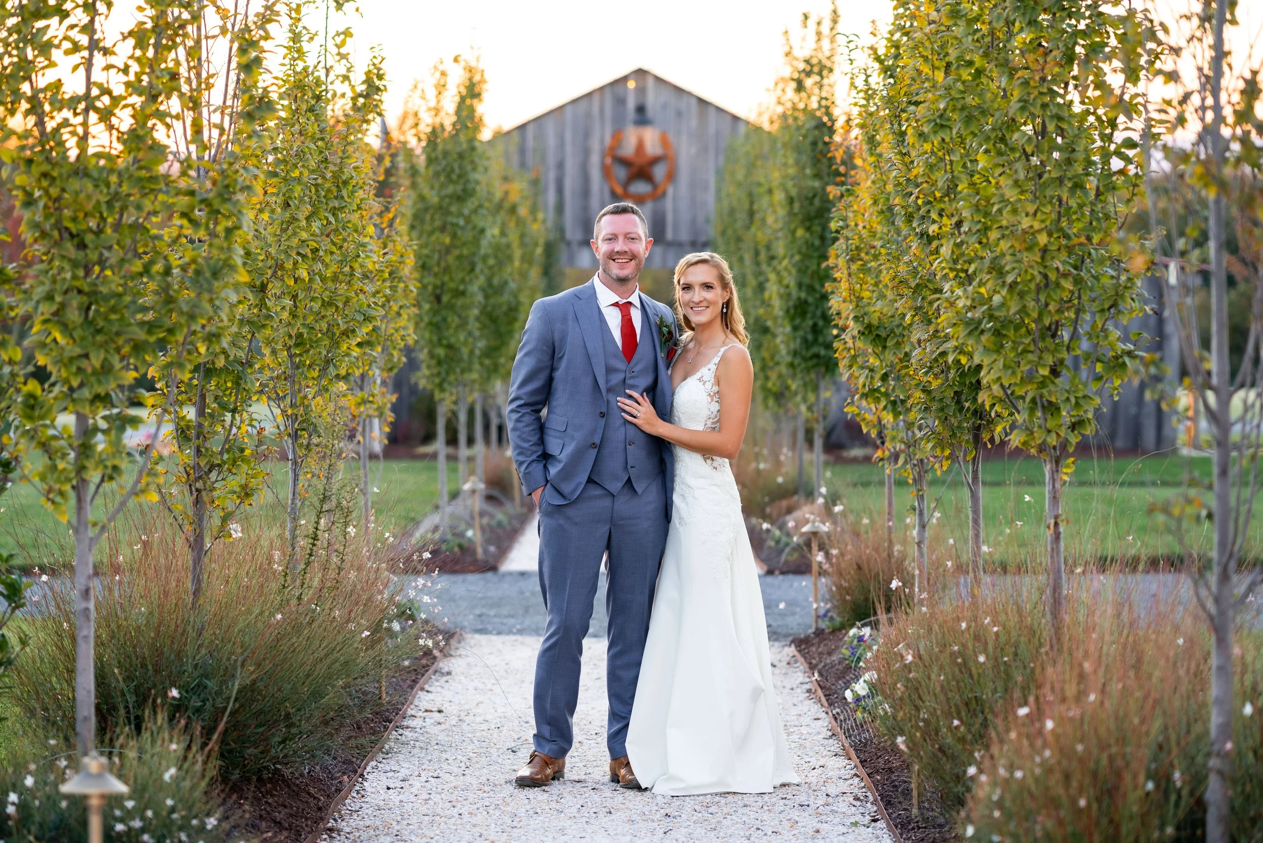 Bride and groom pose for candid and colorful sunset photo at luxurious Hilltop Farm barn venue in Virginia