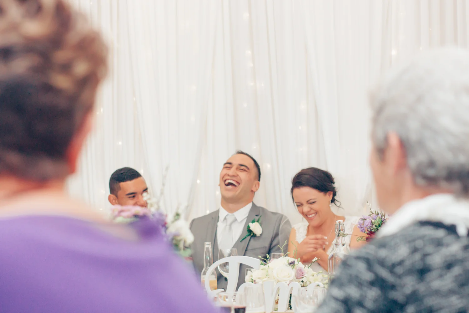 Bride and Groom laugh at wedding reception speeches