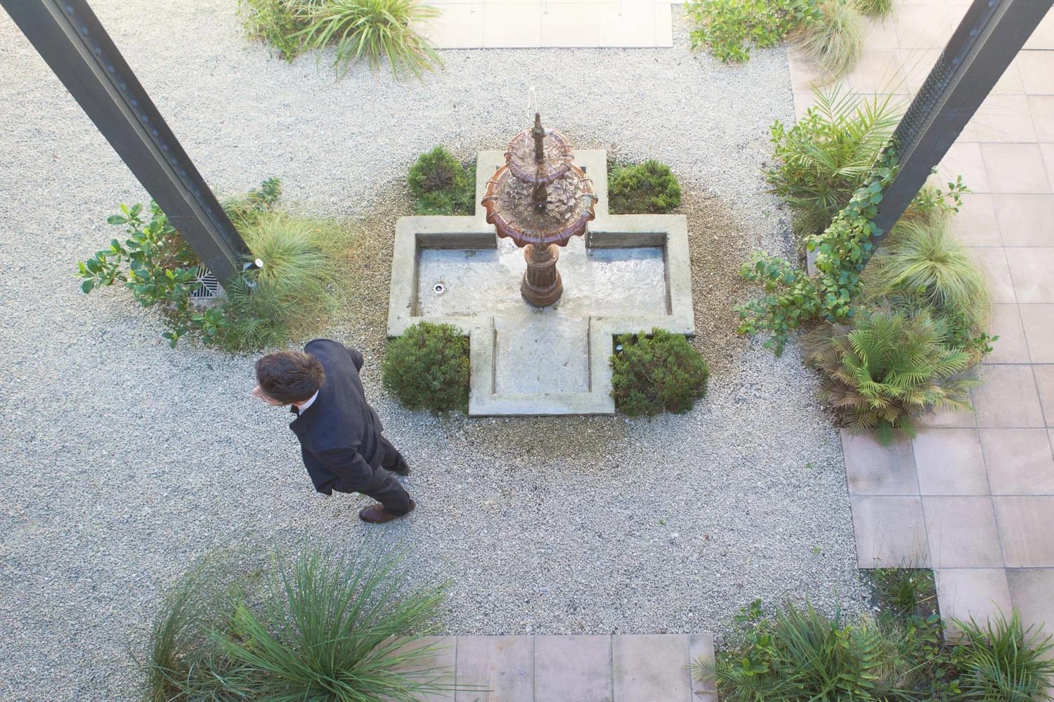 Groom waiting for his bride next to water fountain