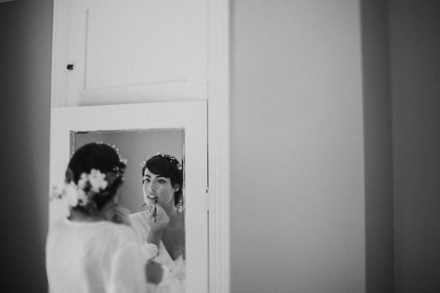 Bride putting on her make up in the mirror