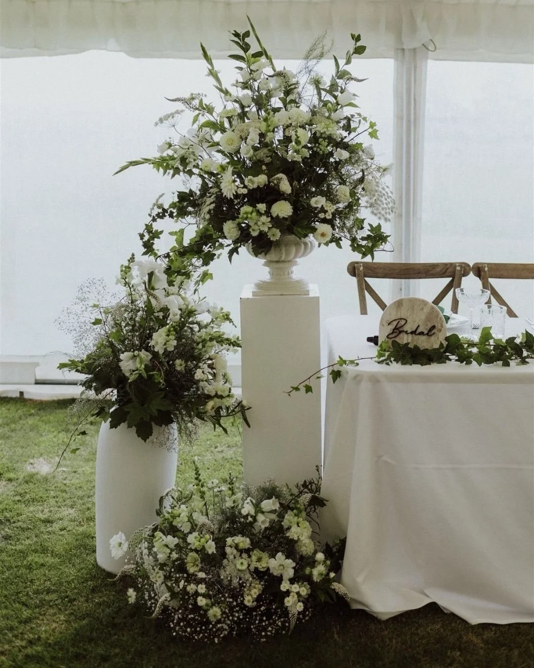 Stunning florals by @bloomwoodflowerdesign 🍃 I loved using these florals and plinths for group photos inside the marquee on this rainy day.