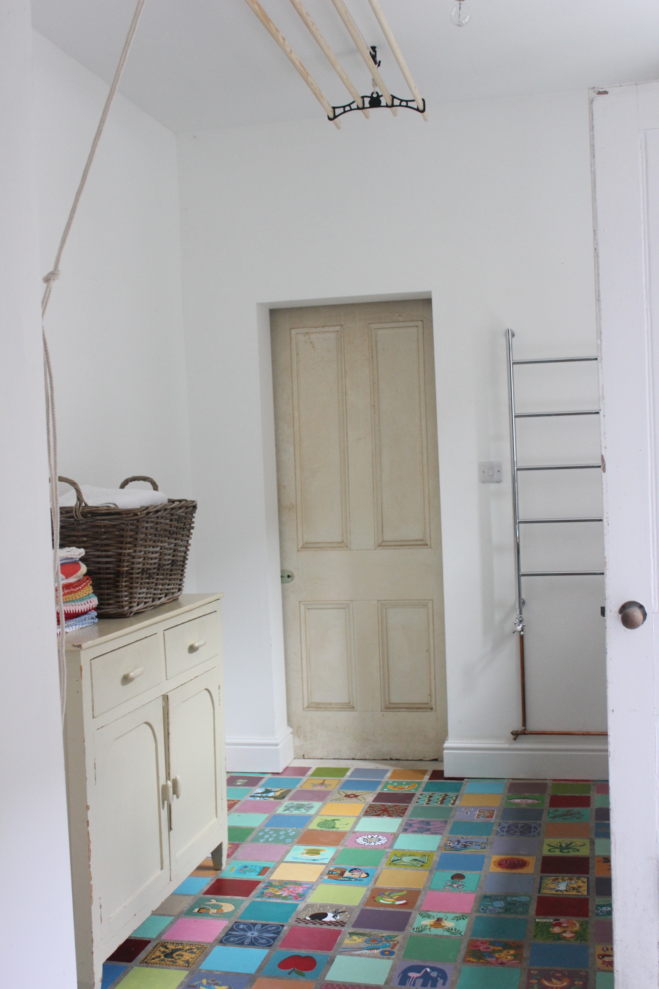 Laundry Room. My mum and Aunt Jackie helped me to paint this floor to make it look like individual tiles. It was a massive amount of work, and we still need to finish the rest of the squares. I'm hoping they will come help me finish it this summer. You can see the entire tutorial here . The Traditional Kitchen Maid® Pulley Clothes Airer is amazing and is very handy when it comes to bed linen. This room is still very much a work in progress. One of the most recent things we had done was in this room, when we had a sink, cupboards, worktops and towel radiator installed. It now feels like more of a proper laundry room, rather than a bare utility space.