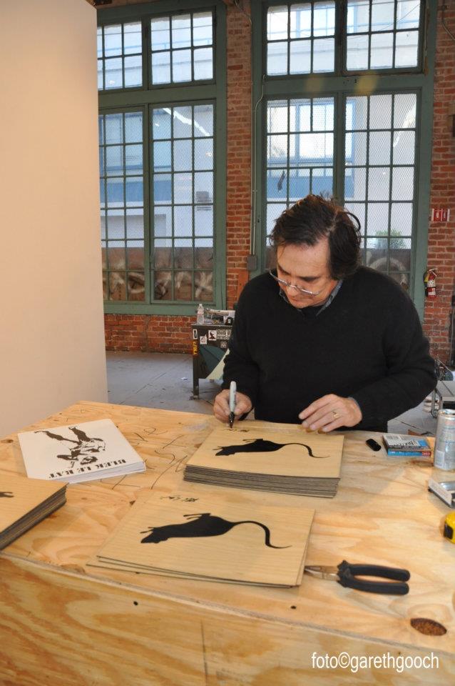 Xavier Prou, a.k.a. Blek le Rat signs the original artwork included in the deluxe edition of "Blek le Rat: 30 Year Anniversary Retrospective"