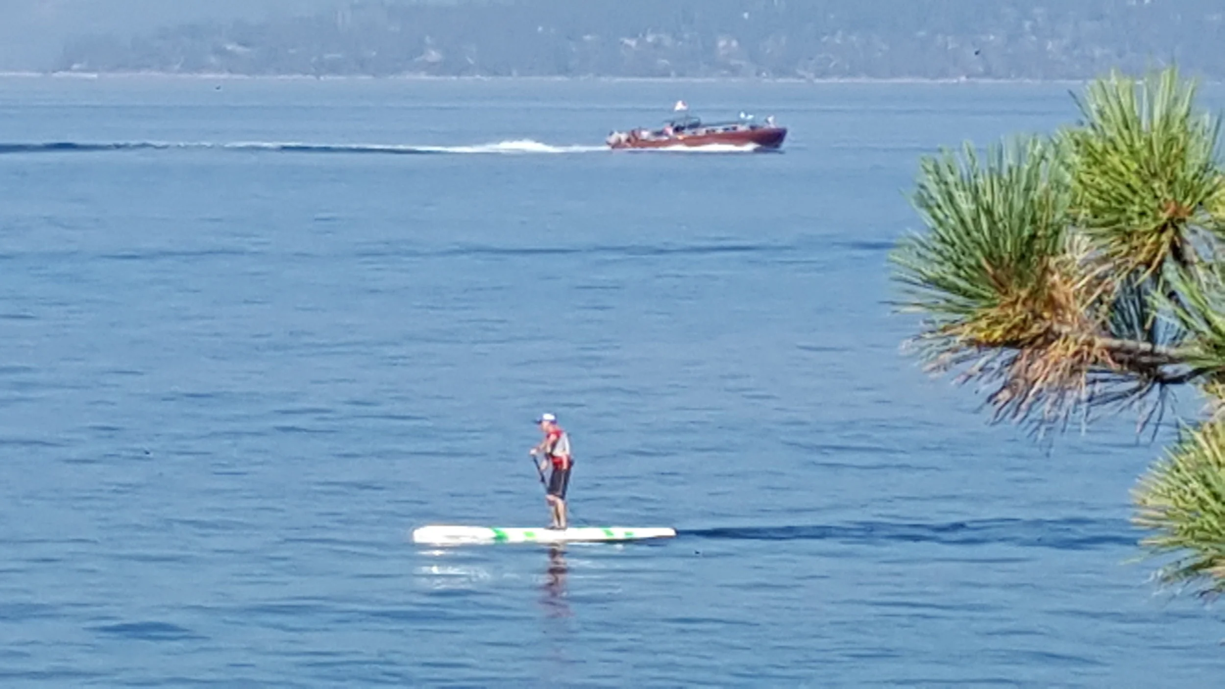 Tom paddles at Sand Harbor in Lake Tahoe with a yacht known as "Thunderbird" in the background. 