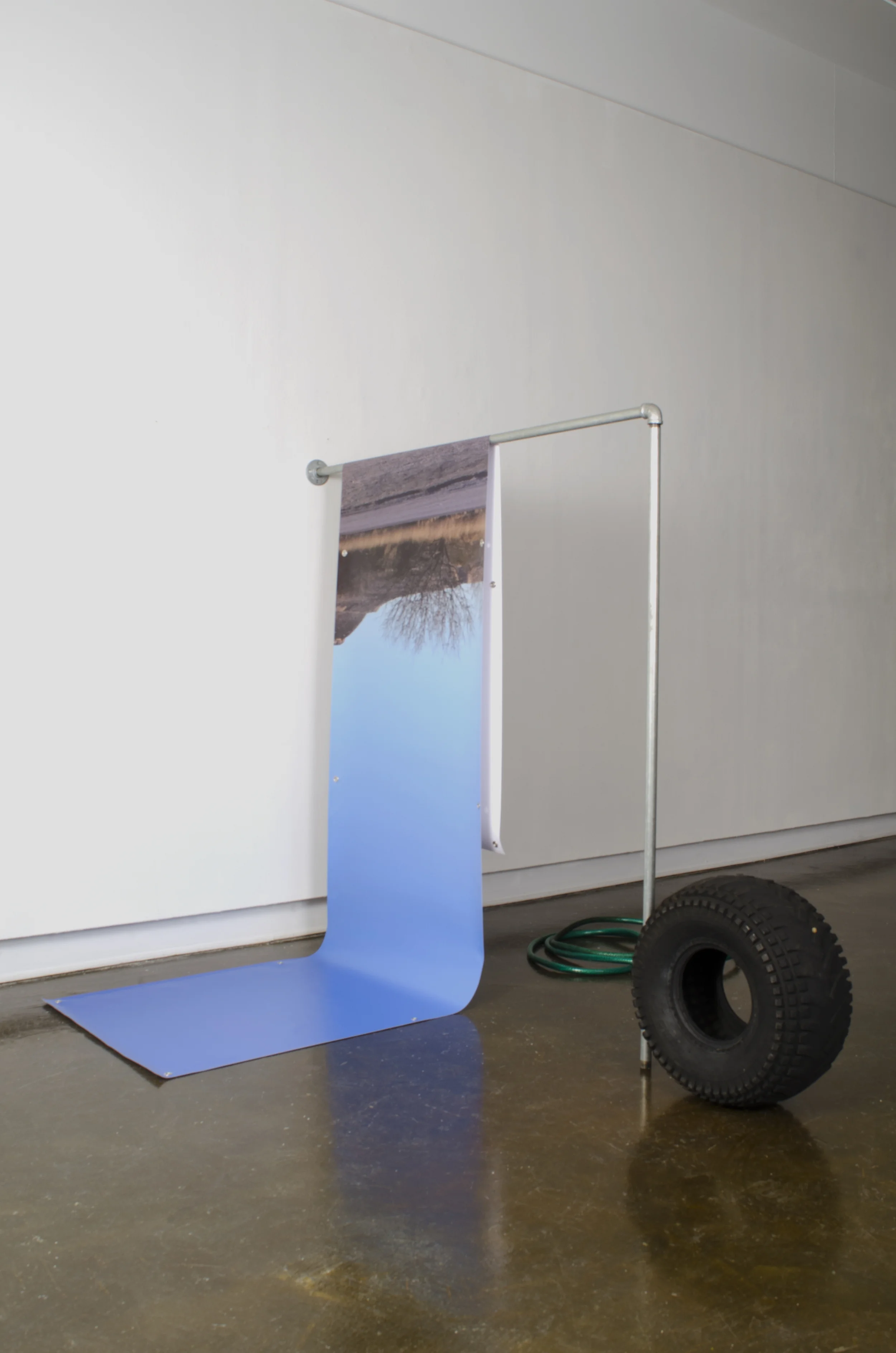 trace | 2016 | hose, photograph on banner, galvanized pipe, atv tire