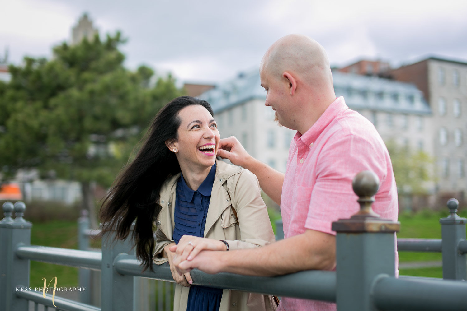 Couple looking at each other and laughing on a bride in the old port of montreal during their engagement photoshoot