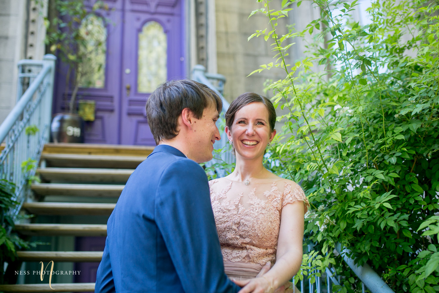 bride and groom laughing in front of purpule house in square saint louis